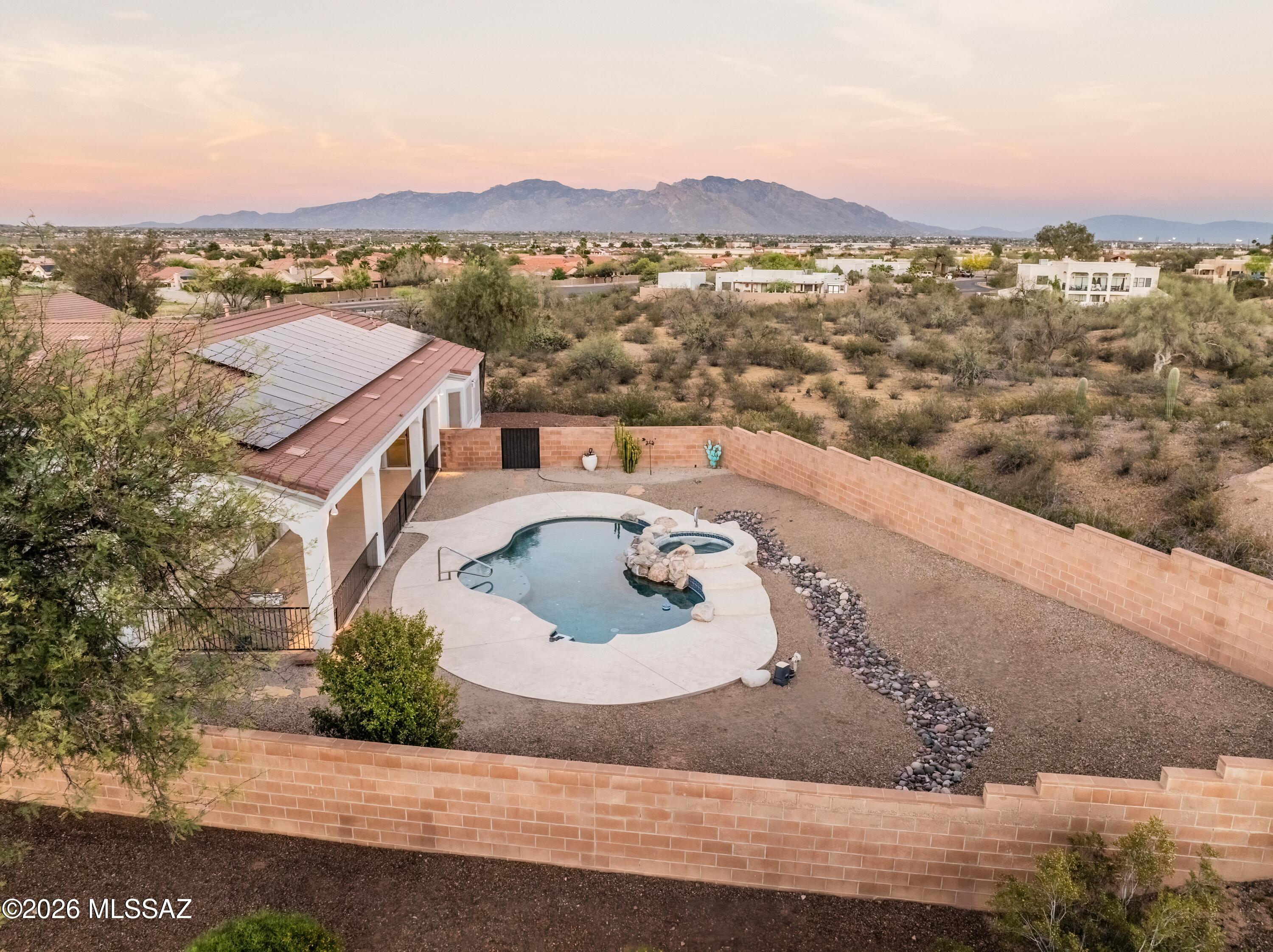Set on a rare 1.12-acre cul-de-sac homesite, this striking contemporary retreat delivers space, privacy, and unforgettable views in every direction. Designed with a versatile, light-filled floor plan and elevated neutral palette, the home effortlessly blends everyday
comfort with refined style. Expansive windows and skylights flood the interiors with natural light, while multiple-flex spaces offer the freedom to create a formal dining room, executive office, or additional living areas tailored to your lifestyle. At the heart of the home, the open-concept kitchen and family room become the ultimate gathering space,
featuring inviting fireplace, granite countertops, a generous island, custom cabinetry, and seamless flow for entertaining. The primary suite is a true sanctuary, complete with
a dramatic three-sided fireplace, spa-inspired bath, and walls of windows that frame serene desert views. Move outside to your private resort where a sparkling pool, spa, and extended covered patio set the stage for effortless outdoor living. Take in sweeping
sunsets over Sombrero Peak and city lights, with Rincon Mountain views stretching to the east with no rear neighbors for ultimate privacy. With a 3-car garage, abundant built- ins, and exceptional storage throughout, this 4-bedroom, 3-bath residence offers both
luxury and livability. Ideally located near premier amenities yet privately tucked away, this exceptional property offers again those breathtaking mountain and city views delivering the very best of elevated Arizona living.  An added plus is this home has OWNED Solar.