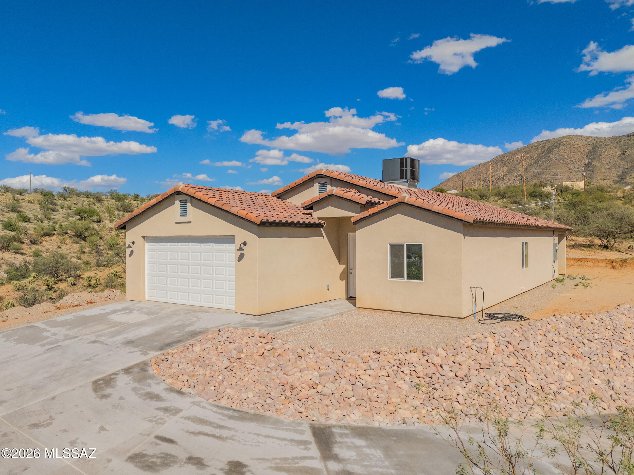 Brand-new 2024 construction on over 1.44 acres in the peaceful Rio Rico landscape! This 4-bedroom, 2-bathroom home offers 1,827 sq ft of thoughtfully designed living space with a modern open-concept layout perfect for everyday living and entertaining. Built from the ground up, everything is new- including the roof, HVAC system, septic, flooring, windows, cabinetry, countertops, and stainless-steel appliances- providing quality, efficiency, and peace of mind. Step inside to a bright and airy interior featuring a spacious living area that flows seamlessly into the kitchen and dining space. The kitchen is designed with style and functionality in mind, showcasing sleek cabinetry, modern countertops, and new stainless-steel appliances. The primary suite offers a private retreat with a walk-in closet and a beautifully finished ensuite bathroom. Three additional bedrooms provide flexibility for guests, office space, or hobbies. Situated on a generous lot, the property offers stunning mountain views and endless possibilities for outdoor living, gardening, or future expansion. Enjoy the tranquility of rural living while still being conveniently located near local amenities. Move-in ready and built with attention to detail, this home is a must-see!