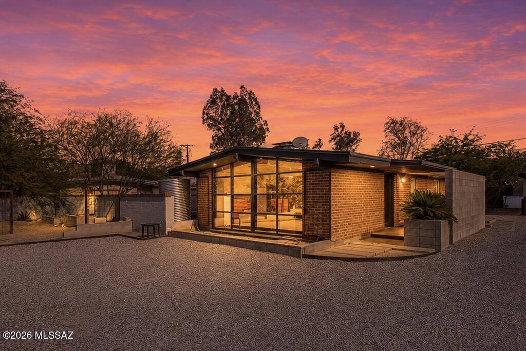 Check out this charming remodeled mid-century home, nestled on a spacious lot  offering Catalina mountain views. Step inside to discover vaulted ceilings adorned with exposed beams, complemented by elegant tile flooring and updated light fixtures. A two-way fireplace adds warmth and charm, while a spacious living room with framed glass walls floods the space with natural light. Indulge in a delightful meal in the bright & open dining room, which features a multi-slider leading to the backyard. The kitchen is a culinary haven, equipped with beautiful wood cabinetry, a gas cooktop, concrete countertops, and a breakfast bar. Relax in the perfectly sized bedrooms, one of which boasts a generous walk-in closet and wood-look flooring. Beyond the main house, a magnificent gazebo with a fire pit, surrounded by trees, offers endless possibilities for transforming your outdoor space into a personal retreat.