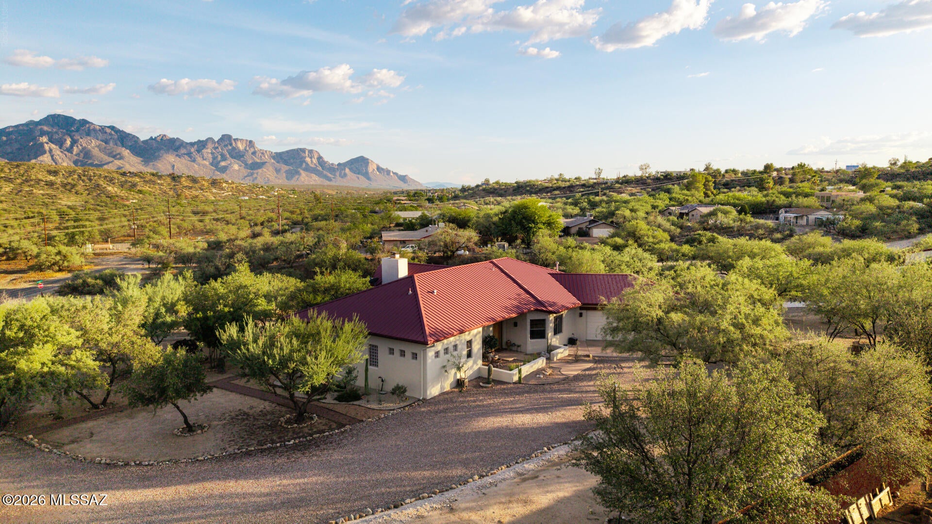 Welcome to your Wow! This custom built  2-bed, 2-bath, 2,119 sq ft single-level home built in 2007 on approximately 2.44 acres with wide-open Catalina mountain views is the home that encapsulates the life you've dreamed of living. The home features Rastra block construction and a metal roof, plus concrete floors, high ceilings, and thoughtful custom finishes throughout. A standout feature is the drive-through main garage that allows entry/exit access to a workshop with a car lift and bathroom, creating a highly functional setup for projects and storage. Outdoor living is well supported with a covered patio off the kitchen and an enclosed patio off the primary suite, both positioned to capture the mountain views.