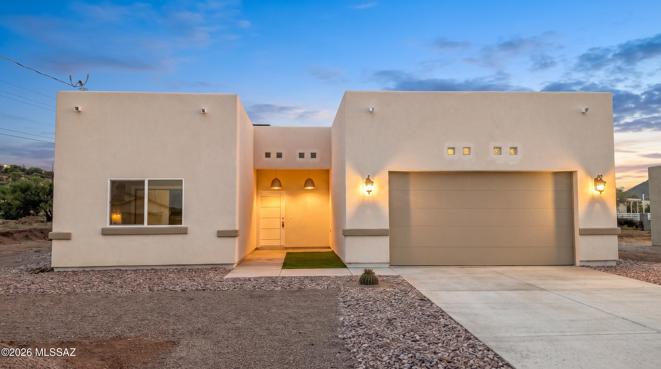 Welcome to 1851 Isabel Ct, a newly built 1,504-square-foot home in Rio Rico featuring modern design and a unique split floor plan for added privacy. Connected to public sewer. The contemporary Santa Fe-inspired exterior sets the tone for the clean, inviting interior. Ten-foot ceilings and an open layout create a spacious feel, while the kitchen stands out with light wood cabinetry, gold hardware, quartz countertops, a large island, pendant lighting, and stainless steel appliances. The matching cabinetry and quartz counters continue into the dedicated laundry room, adding a thoughtful touch. Modern finishes, a bright interior, and a practical layout make this home a great fit for everyday living. Enjoy the opportunity to make this contemporary Rio Rico home your own.