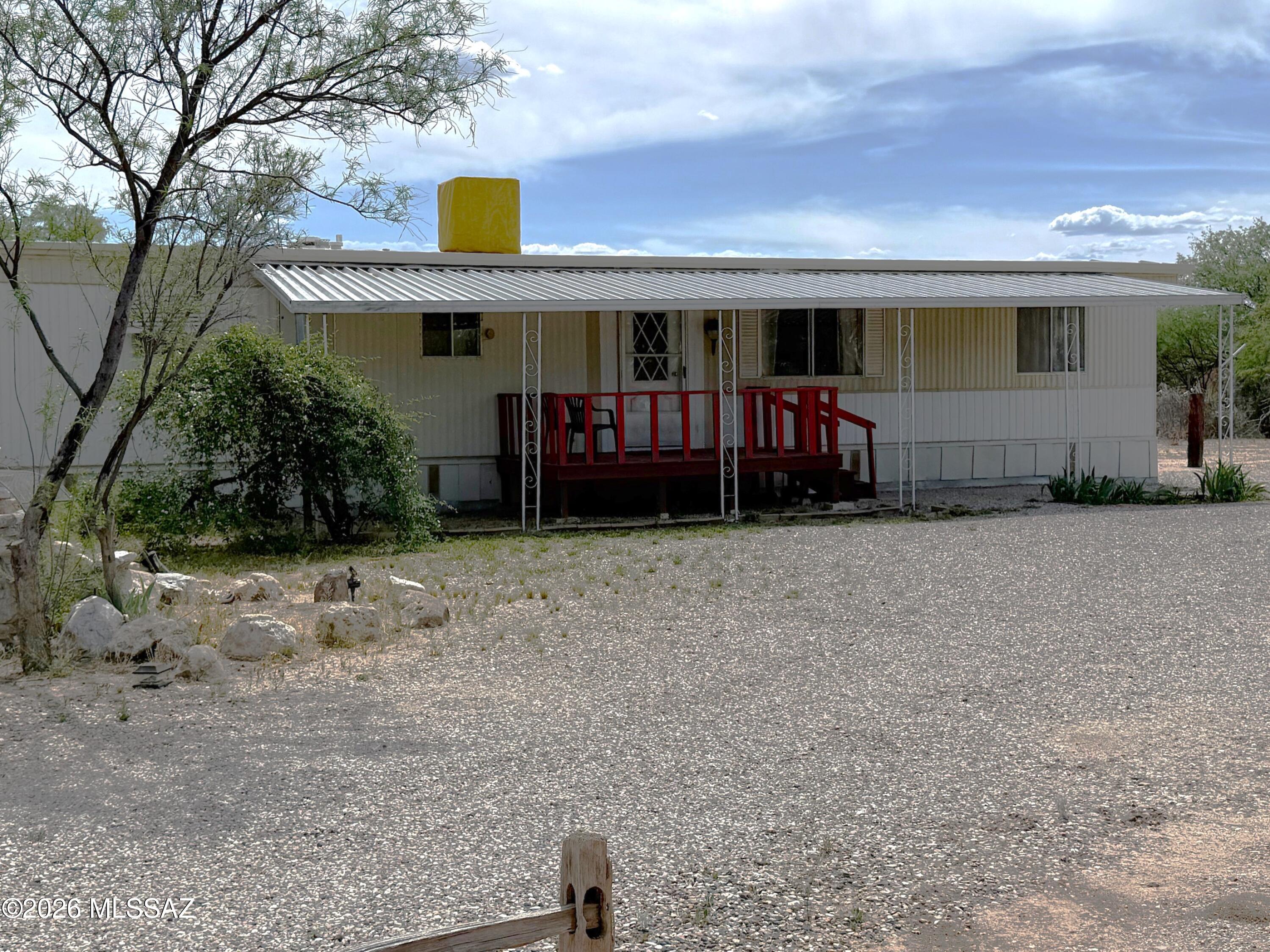 Check out this vintage 1978 Manufactured Home on 1.23 acres with mature trees, handcrafted water fountain, bird houses and desert tortoise enclosure. The house is 2 bedroom 1 bath with a solid metal roof, covered front deck and attached 1 car carport. The interior is mostly original and in good shape. The kitchen and bathroom have been updated with new countertops, sinks and faucets and a new gas water heater has been installed.There are several structures on the property including a dog house, a fenced garden area, mature pomegranate trees and a nice wooden site built workshop on cement slab with electric. This property could make a nice starter, retirement home or place to get away to in the winter. There's even room for a horse. Easy access to I-!0 and minutes from Downtown Benson.
