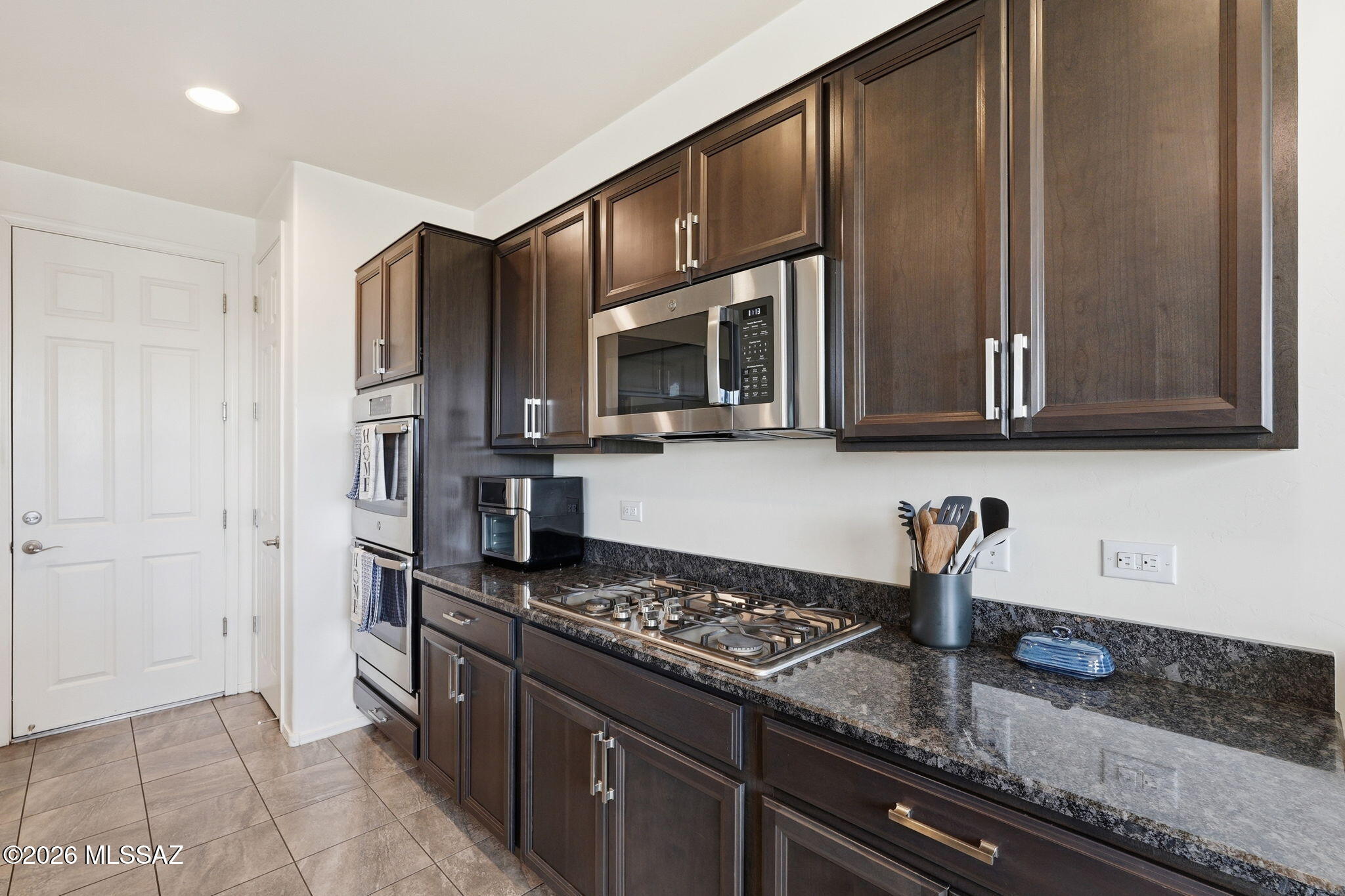 In Rancho Sahuarita Community, this home has a spacious 3-bedroom, 2.5-bathroom layout with a loft. It features an ASSUMABLE LOAN at 4.375% interest. The home offers a great room concept with 9' ceilings, neutral stone and tile flooring, and abundant natural light. The gourmet eat-in kitchen has espresso cabinets, granite countertops, a breakfast bar island, a reverse osmosis system, and a water softener. The refrigerator, washer, and dryer are included. Outside, the large private backyard overlooks the natural desert, has only one adjacent neighbor, and features a covered patio, professionally installed pavers, and artificial turf. This is a must-see! At this price and interest rate, it won't last long!
