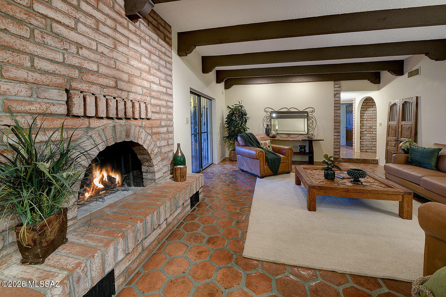 Classic Tucson territorial-style home by Rued Construction in highly sought-after Catalina Foothills Estates #8. Ideally situated on a quiet cul-de-sac on a CR-1 lot within the prestigious Catalina Foothills School District #16, this charming 3-bedroom, 2½-bath residence offers approximately 2,250 square feet of authentic Southwestern living. A brick paver driveway leads to a welcoming front courtyard with wrought iron gate and trellis ceiling. Inside, the living room show cases exposed burnt adobe walls, neutral ceramic tile flooring, and an adjacent formal dining room—perfect for entertaining. The inviting family room features distinctive hexagon Saltillo tile floors, a dramatic floor-to-ceiling burnt adobe ''Heatalator'' fireplace, soaring ceilings with exposed beams and corbels, and a comfortable breakfast area nearby. The galley kitchen offers generous cabinet and counter space and connects seamlessly to both the breakfast area and formal dining room. The gracious ensuite primary bedroom opens to the rear trellised patio, creating a peaceful indoor-outdoor retreat. Additional features include a spacious 23' x 20' two-car garage with a large walk-in storage room. The expansive rear trellised patio with red brick flooring overlooks an oversized backyard complete with a pool, block-stuccoed rear wall, and sweeping, unobstructed Catalina Mountain views. Conveniently located near La Encantada, premier dining, galleries, schools, and the renowned The Westin La Paloma Resort & Spa. See to appreciate.