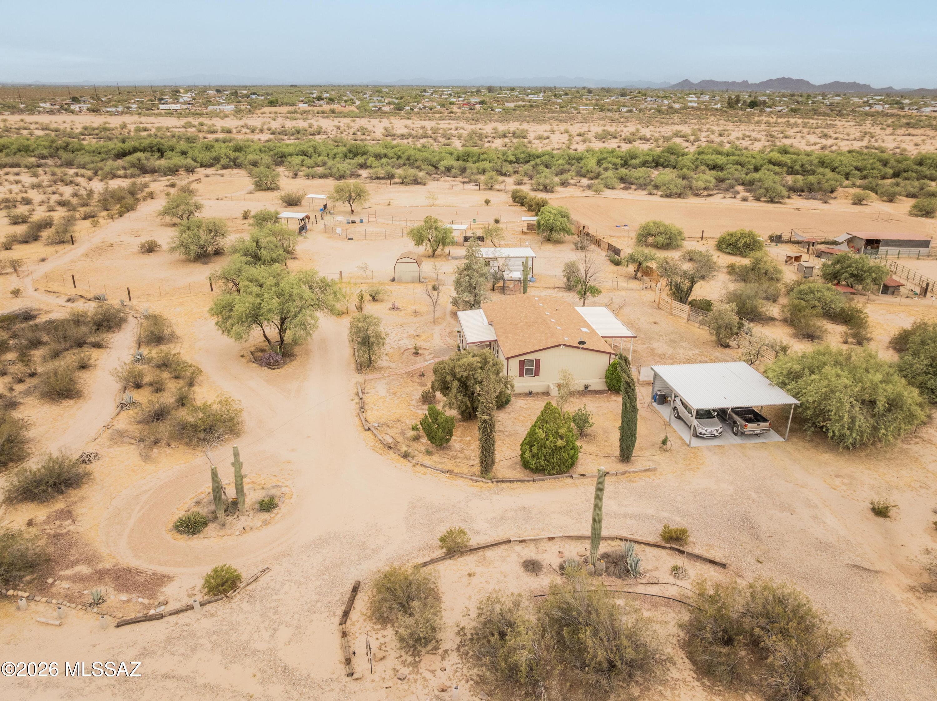 Charming 3-bedroom, 2-bath manufactured home on 4.39 acres of turnkey horse property with stunning mountain views. Features include an open floor plan, covered front and rear patios, chain-link fenced yard, surveillance system, new HVAC (May 2025), and new water heater. Equestrian amenities include horse stalls, large turnouts, steel shade structures, lighted 58x112 riding arena, powered barn/shop and hay storage, additional covered stalls, 220 power, and storage shed with solar lighting. Detached 2-car steel carport, privacy fencing, and dusk-to-dawn lighting add convenience. Located just 15 minutes from I-10 near Marana Veterinary Clinic and Avra Valley Fire Department. ****Last listing 5.30pm No showing after 6pm please**