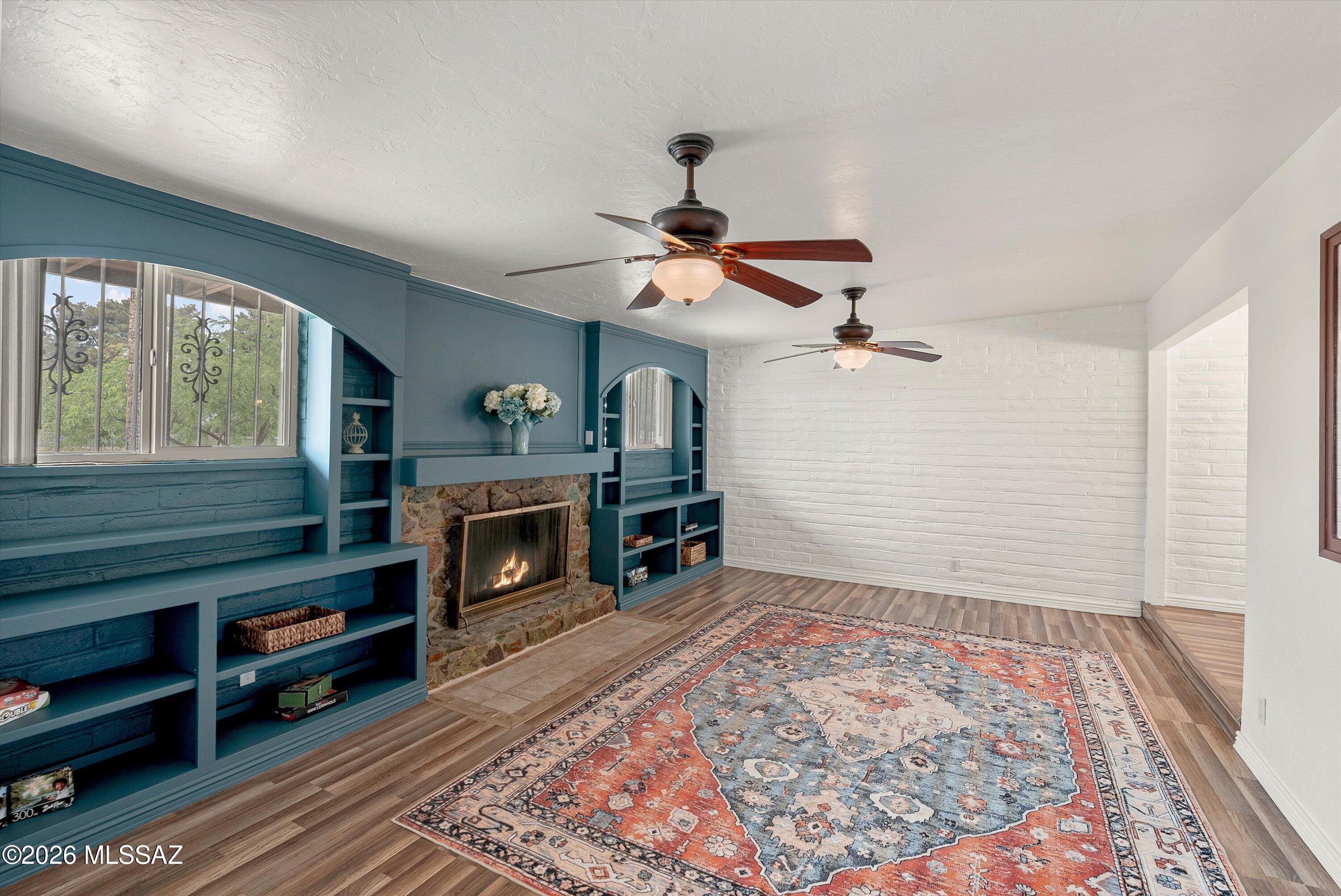 Discover a home that perfectly balances vibrant community access with peaceful backyard privacy. This charming home greets you with a step down into the living room showcasing beautiful teal built-in shelving around a classic stone wood-burning fireplace. The generous kitchen offers stainless double ovens and a sprawling peninsula for effortless meal prep. Enjoy unmatched privacy in the expansive backyard oasis, complete with a gazebo, fire pit, versatile storage sheds, and no rear neighbors thanks to the alley behind the home. The location is truly unbeatable: situated directly across the street from an elementary school and a vibrant park with a pool and splash pad. Make this uniquely situated, character-filled property your next address.