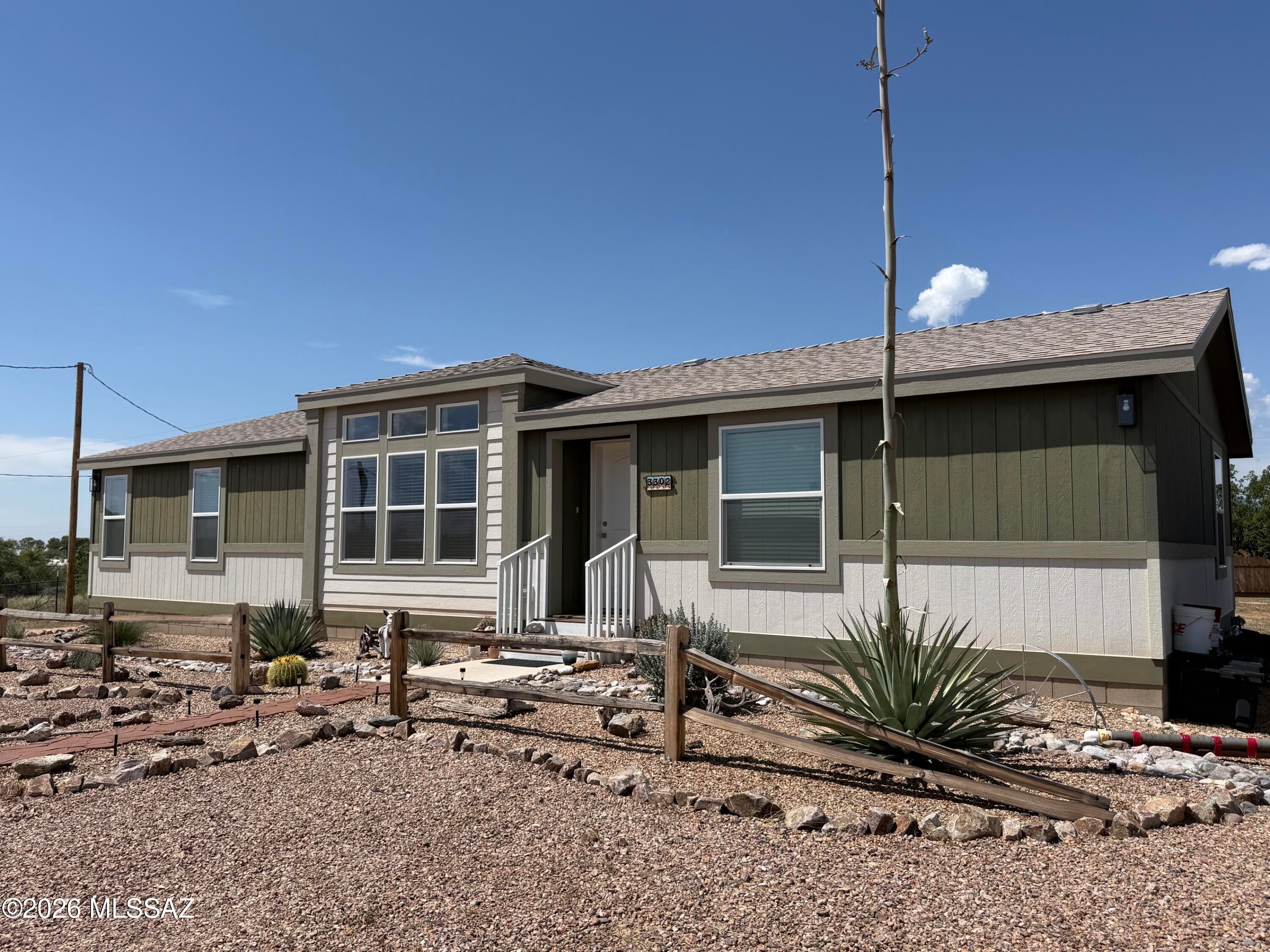 Beautiful move in ready 2023 Cavco Manufactured Home featuring 3 spacious bedrooms, 2 full bathrooms, and a bright, functional layout located in the J-Six Ranch area of Benson. Enjoy 1.59 usable acres with paved road access, its own private well, plenty of room for vehicles,  animals, or outdoor hobbies plus a full RV hookup. The thoughtfully designed, attractive landscaping lets you relax outdoors and enjoy quiet rural living while remaining just a quick 30 minute commute to both Tucson and Sierra Vista / Fort Huachuca. No HOA.