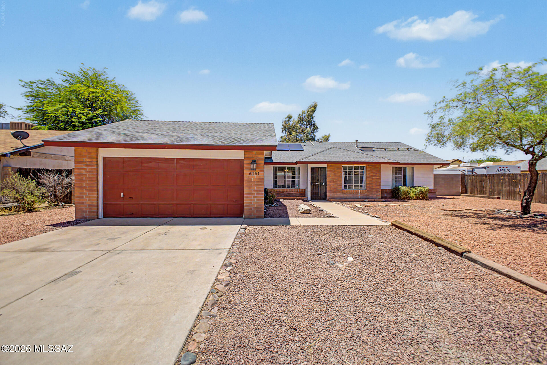 Northwest side home in a quiet neighborhood. Move-in-ready. Spacious open floor plan features a cozy fireplace. High ceilings add to the airy feel, complemented by wood-look flooring, ceiling fans, custom paint, and abundant natural light. The kitchen includes stainless steel appliances, a tile backsplash, track lighting, ample cabinets, and a peninsula with a breakfast bar.  3 right sized bedrooms. Solar panels for added energy efficiency and savings.   Large backyard has a covered patio and mature shade trees. Close to everything, including I-10, schools, and shopping. This rare gem won't disappoint!