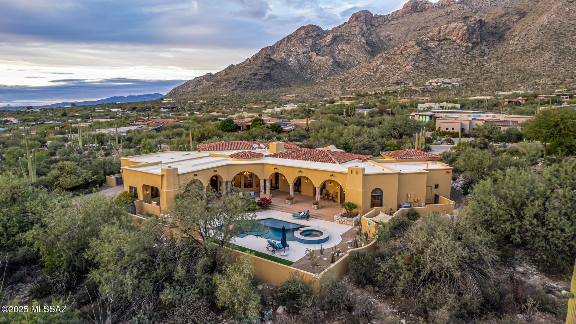 Discover a rare masterpiece nestled in the prestigious Pima Canyon Estates, a community celebrated for seamlessly blending stunning architectural design with the majestic Sonoran Desert nature. This timeless Mediterranean villa, designed by architect Simmons Home Design and prominently featured on the architect's own website, offers unparalleled security and privacy within its exclusive, double-gated setting. Situated perfectly on a prominent corner lot, this split-floor plan home boasts the convenience and curb appeal of two separate driveways, providing a grand sense of arrival. Step inside to a world of artisan craftsmanship with a refined European feel. The floors feature premium Travertine tile laid in an intricate Versailles pattern while the kitchen and living spaces are graced with custom Knotty Alder cabinetry.  Natural light streams through unique, custom stained glass window accents.  This elegance is completed by finely hand-carved Cantera stone detailing throughout. The current owners have added the ultimate Arizona essential: a beautiful private swimming pool, transforming this custom estate into a luxurious, everyday retreat. Welcome to the ultimate Catalina Foothills Lifestyle where location is everything.  Beyond the exclusive double gated community, you are minutes from high end retail and gourmet dining at La Encantada Shopping Center, and immediate access via private gate to the famed Pima Canyon Trailhead for world-class hiking right in your backyard. 
This is an enduring work of art and the key to an unmatched, custom lifestyle in Tucson's most sought-after community.