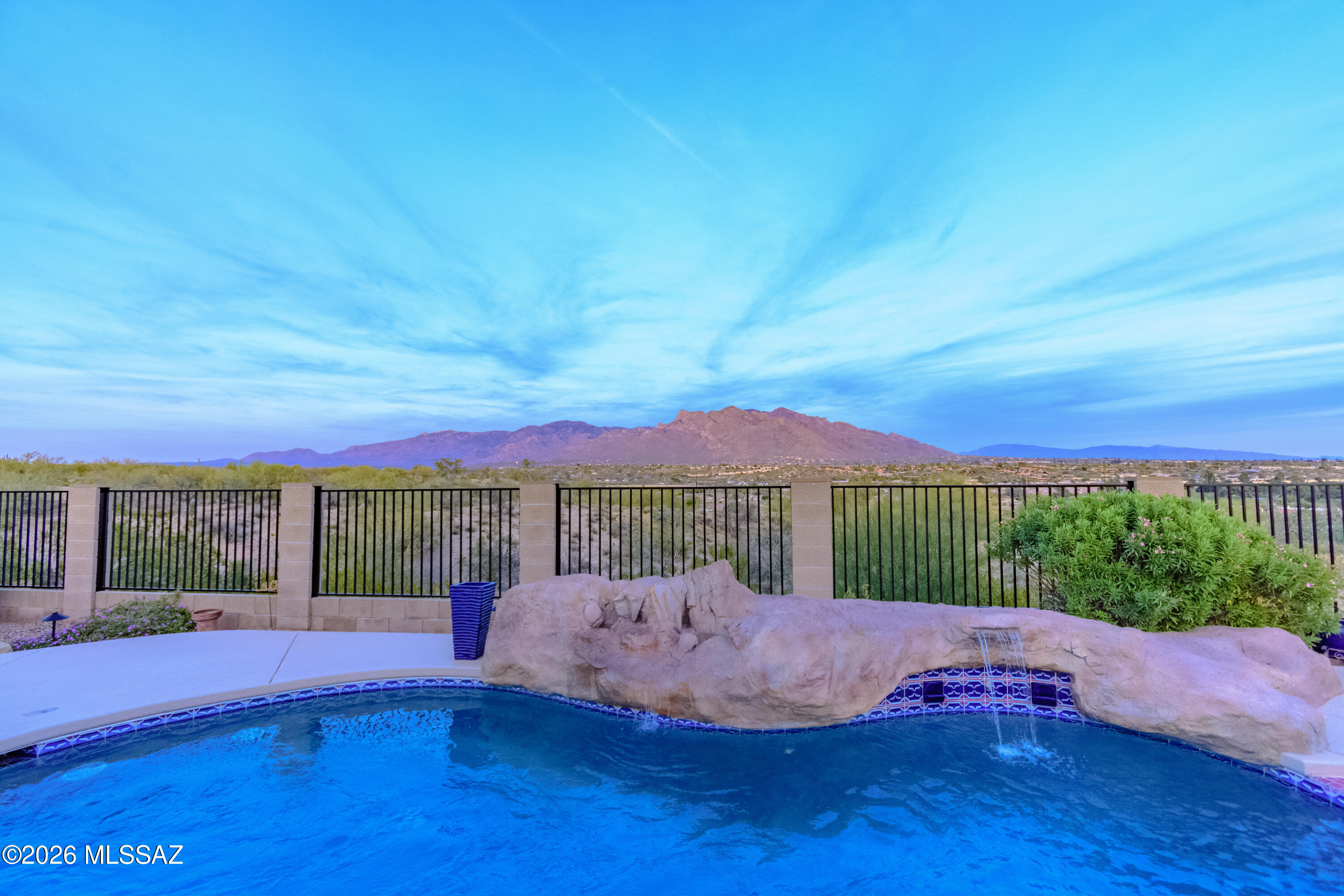 This is THE one you have been waiting for.  Absolutely stunning panoramic Mountain and city views. This a gorgeous, meticulously maintained/upgraded home.  Original owner. Brand new roof. Newer painted exterior. Designer tile Versailles pattern layout.  Upgraded fans and light fixtures. Great room that soaks in the views. Gas fireplace. Granite kitchen countertops with beautiful wood cabinets. Primary bedroom with extraordinary views. Beautiful bathroom vanity countertops and cabinets. Sparkling pool.  View fenced backyard. No neighbor to city view side. Garage floor refinished.  Sun screens on west and south windows. Cameras convey. Very popular neighborhood of The Bluffs II.  This truly is one of the best views the desert provides. Close to OMNI Tucson National.