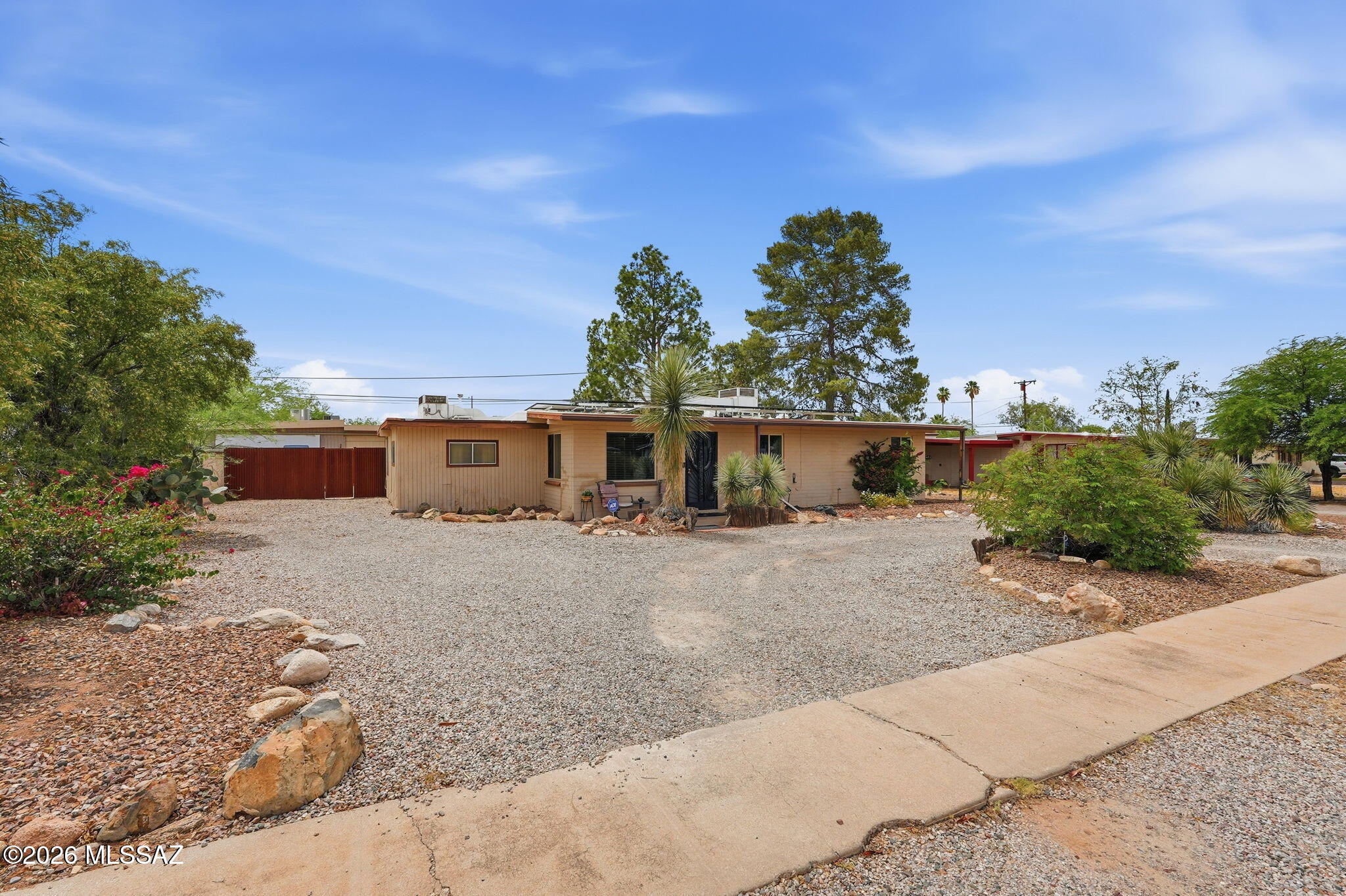 Charming home on a large lot with no HOA, leased solar panels, and a huge backyard! This 5-bedroom, 2-bath residence has no carpet and offers both a formal living room and a family room, perfect for entertaining or relaxing.   Enjoy the covered patio, decorative front landscaping, desert plantings, and RV parking space.  A wonderful Tucson home combining comfort, efficiency, and charm!