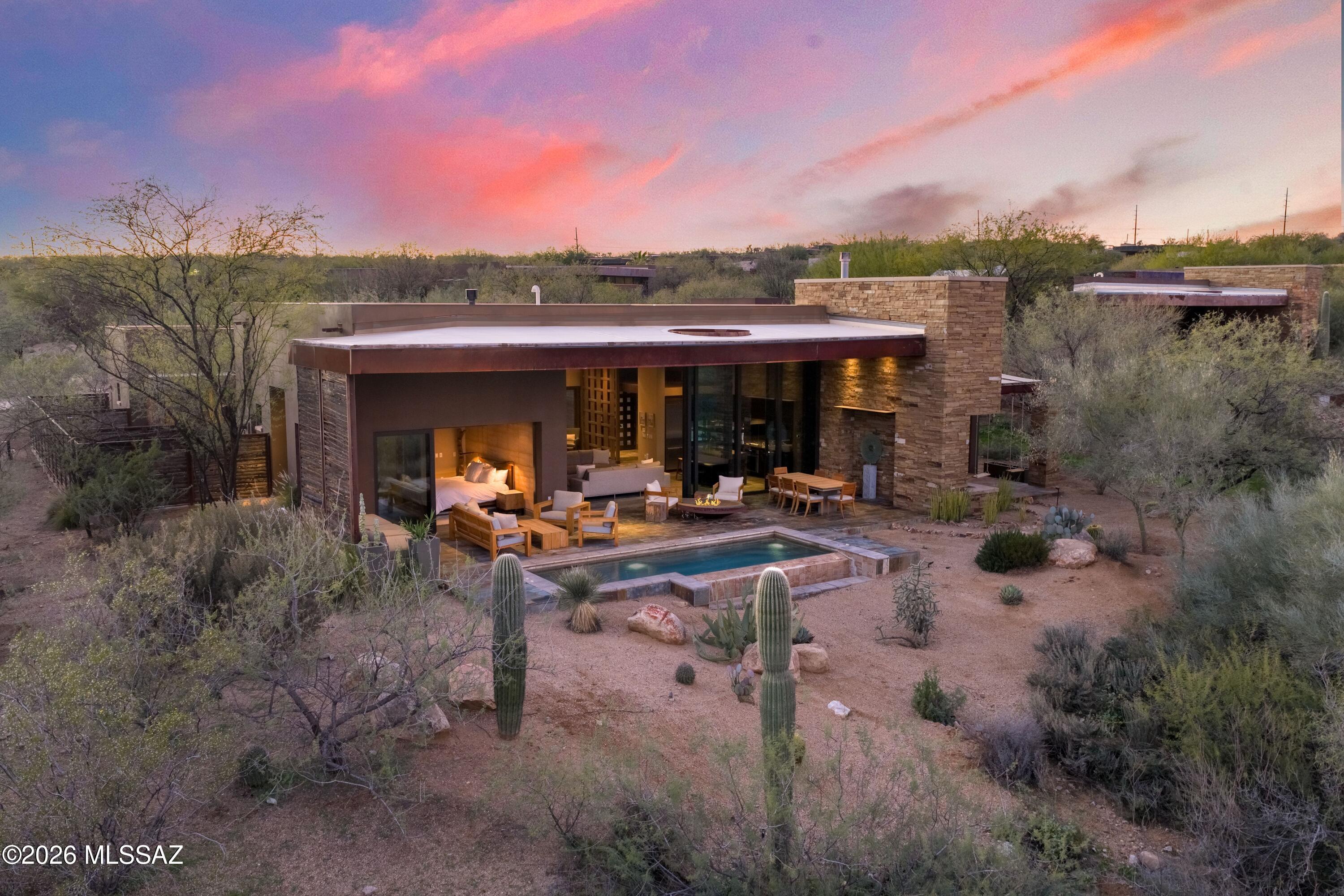 Welcome to your private wellness sanctuary, tucked away in a small enclave of homes on the grounds of MIRAVAL Resort in Tucson, AZ. This residence and this lifestyle are distinctly different. Here, you hit the pause button and recharge. With the amenities of a world class destination spa at your doorstep, it's easy to do. Created by the forward-thinking minds at MITHUN of Seattle, this home intentionally feels subdued from the approach, while offering a powerful experience upon entering. Blending with the earth and honoring the desert were top of mind for a sustainable build. Awarded Silver LEED status from the Green Building Council, the property integrates materials, textures and colors that speak to the surrounding landscape. Seamlessly blending indoors and out, with unobstructed views of the Catalina Mountains, this setting invites you to relax, breathe and connect with nature. Layers of the desert unveil themselves as light moves throughout the day. This is truly a place that allows the mind to clear and opens space for creative thoughts.

A thoughtful layout offers the ability to comfortably host guests or delineate spaces for different functions. The 2400 sq ft main house includes the primary suite, guest bedroom, guest bath and great room flowing to an expansive patio from which you feel completely secluded. With a gas fire pit, infinity plunge pool with swim jets and outdoor daybed, this area adds substantial living space to the home. A 700 sq ft detached casita provides a private setting for guests with separate living and rest spaces, ensuite bath and courtyard with a jetted spa.

Homeowners and their guests may choose to immerse themselves in the experiences at MIRAVAL as little or as much as they desire. The resort has created an environment in which a wellness journey is completely individual and offers a robust variety of facilities, services, and activities. A sampling of offerings includes spa treatments, fitness classes, yoga, meditation, hiking, mountain biking, equine therapy and horseback riding, lectures, culinary classes, and spiritual sessions. With on-site dining, concierge and transportation services, everything needed is at your fingertips.

A unique and easy to own asset, this property would work beautifully as a vacation home, seasonal residence, or corporate retreat. There is the option to rent the property through the resort-managed rental program when unoccupied, if desired.