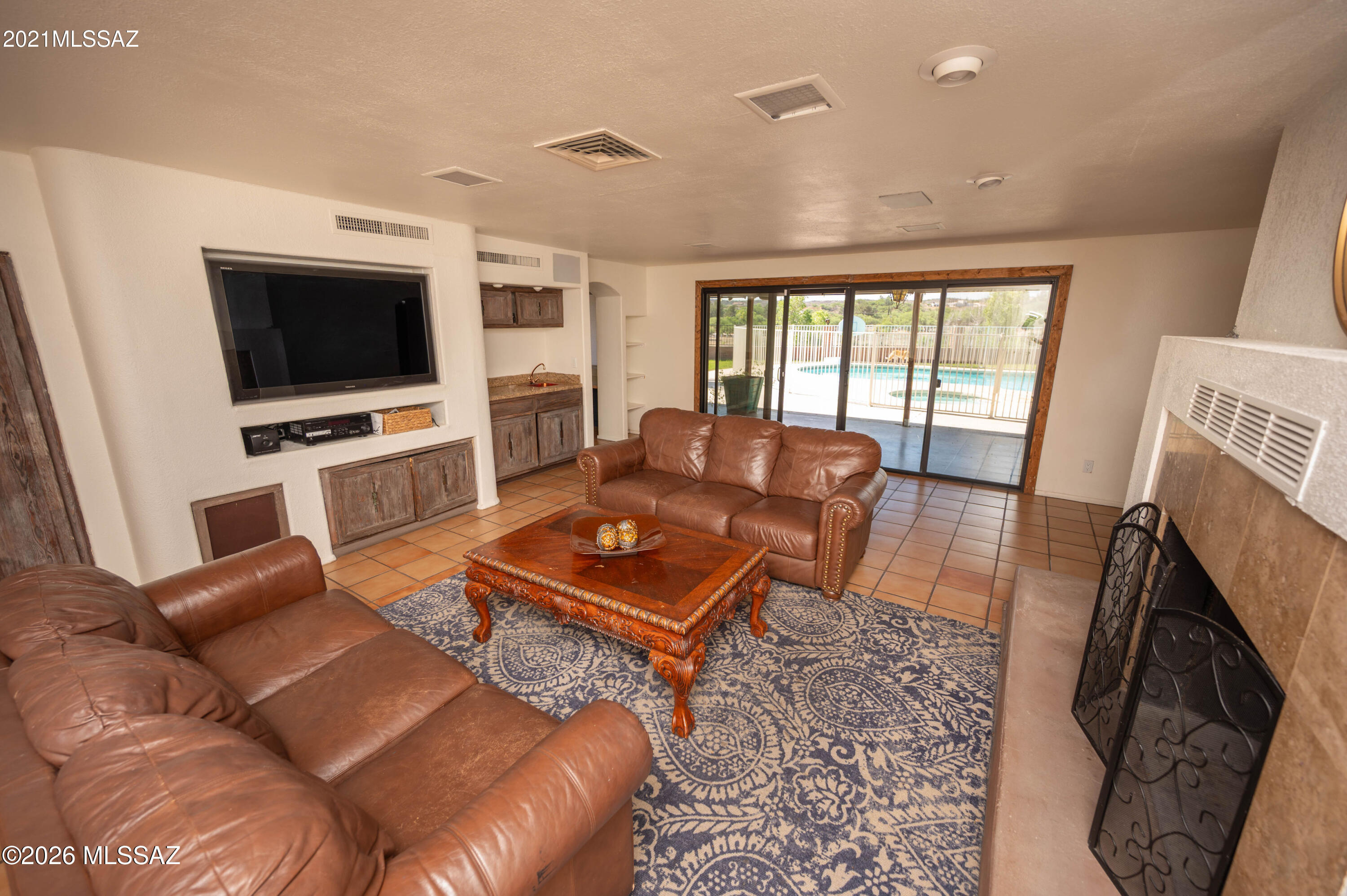 This lovely brick home sits atop a hill on a corner lot in Meadow Hills, offering sweeping 180-degree views. Wake up to golden sunrises and unwind with peaceful sunsets. Inside, you'll find three bedrooms with walk-in closets and three full bathrooms. The ceramic tile flows throughout, with warm wood or laminate flooring in the bedrooms. The living room features a cozy fireplace and an inviting entertaining space. The bright kitchen includes all appliances and a breakfast bar. A spacious laundry room with washer and dryer and an extended two-car garage add convenience. Outside, enjoy a lush yard, covered patio with grill and sink, and a gated, heated pool, plus a nearby park and driving range.