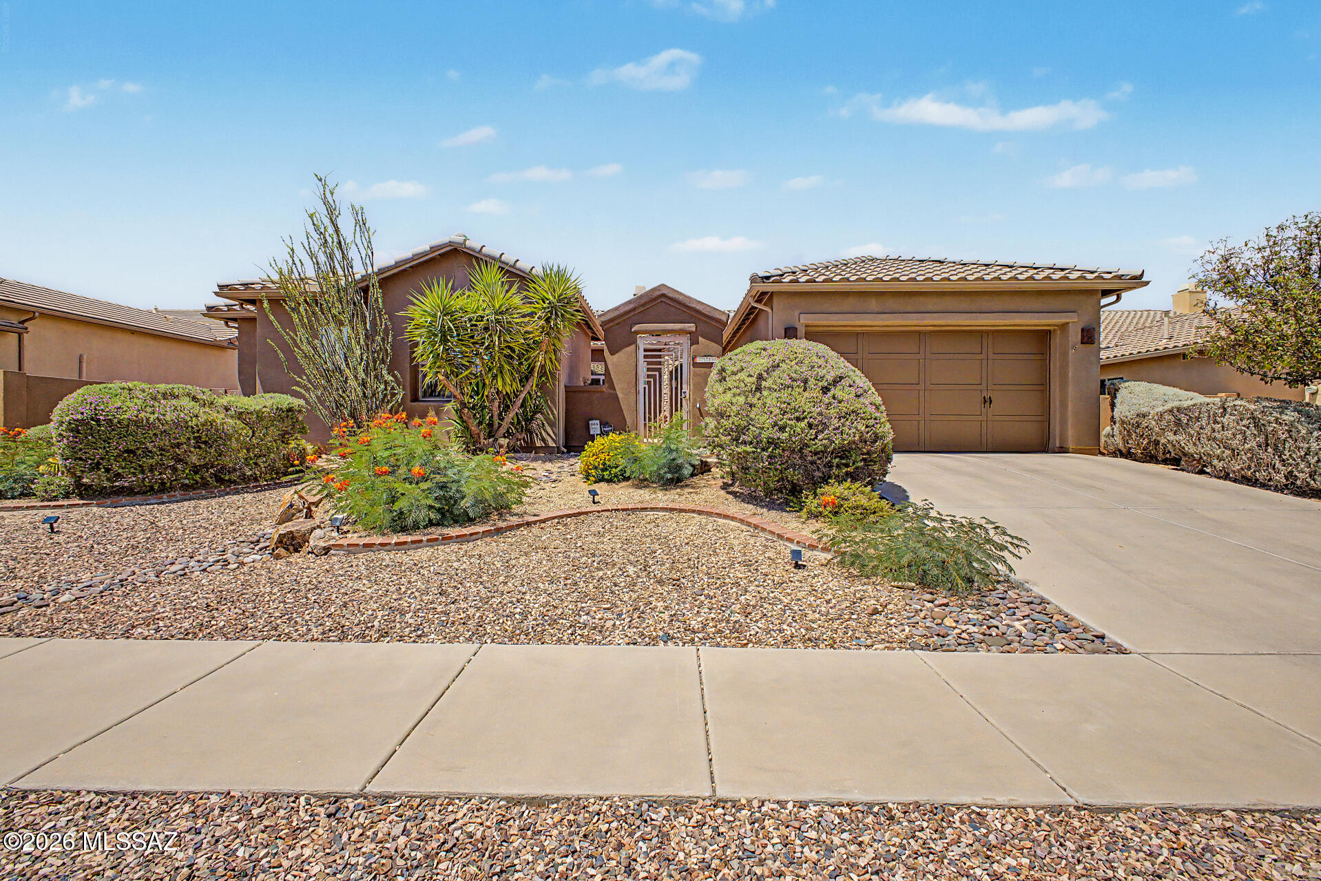 Welcome home to this stunning single-story Pulte DaVinci model. Beautiful landscaping, a two-car garage, and a gated courtyard with flagstone flooring, a water feature, and a fire pit create a warm and inviting first impression. Inside, spacious living areas feature large-format stained concrete floors, soaring ceilings, abundant natural light, a cozy fireplace,  and a soothing palette. The chef's kitchen showcases extensive cabinetry with pullout shelves with crown molding, tile backsplash, granite countertops, GE Monogram stainless steel appliances, and a large island perfect. for casual dining. Relax outdoors on the covered patio, practice your putting on the green, or enjoy the versatile spool, heated or cooled to your preference. This exceptional home is a must -see! The airy main bedroom promises a good night's sleep, offering a spa-like bathroom with double vanities and a separate shower & tub, plus a walk-in closet for an easily organized wardrobe. The den is the perfect spot for a hobby area or workspace. Enjoy outdoor living in the backyard, complete with a covered patio ideal for morning coffee, a built-in BBQ perfect for gatherings, a putting green, and a relaxing hot tub with a waterfall. Hurry up, this gem won't last!