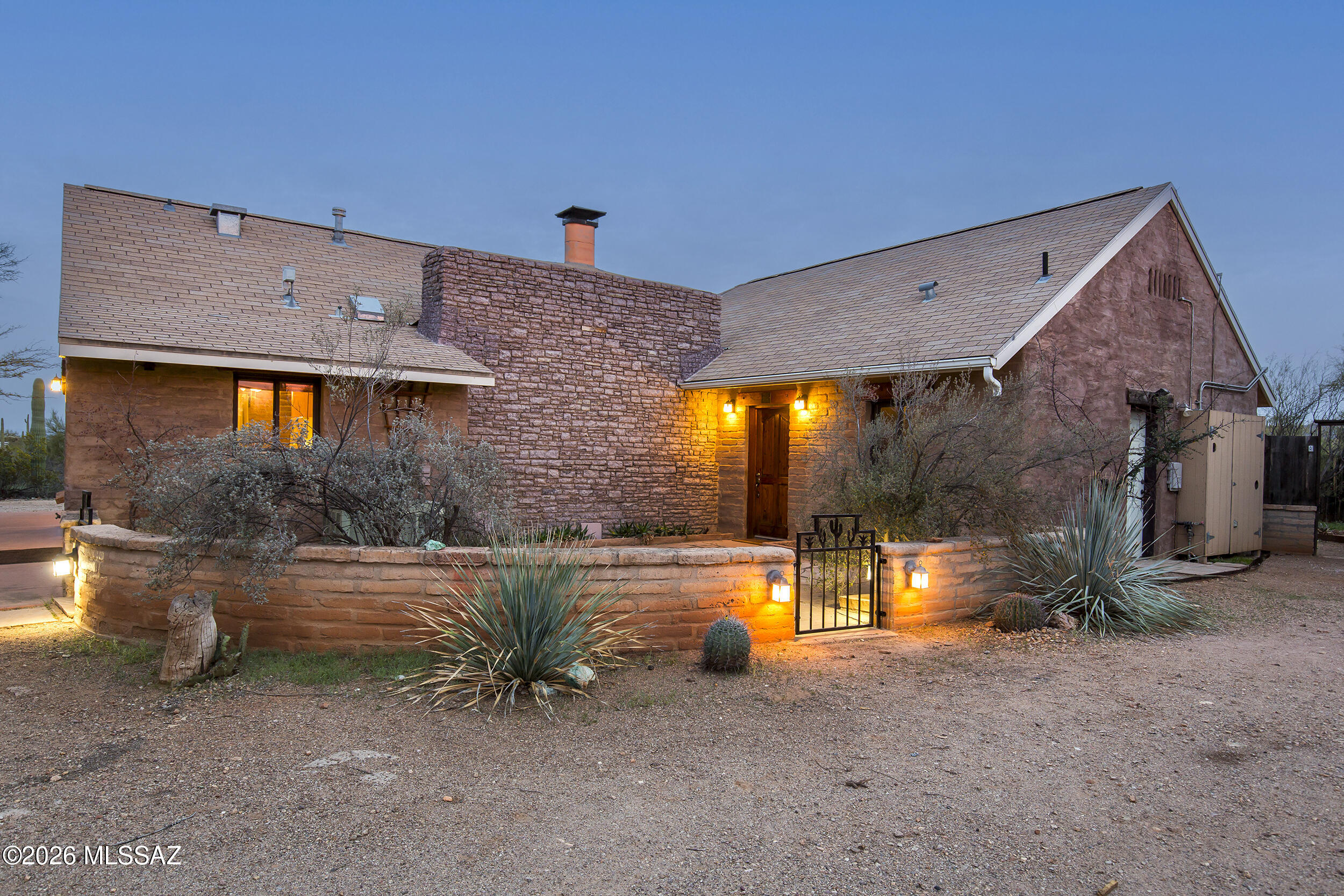 Original owner, saguaro studded, unique adobe home on 3.2 acres with lots of room for all of your ideas! Every detail has intent, from the exposed adobe inside, the beautiful wood with under lighting plank ceilings with the limestone fireplace, a covered outdoor bar & the adobe half wall courtyards in the front & back & the 500 sq ft east facing patio to catch the sunrises & sunsets. In the main house you will find 2 huge bedrooms with a spacious dual sink bathroom & a one of a kind living room. Off the front patio or bedroom, a large bonus room awaits your purpose. The back studio is spacious with a jetted tub, full kitchen & gorgeous views of the Tucson Mtns & rural desert. The flat, usable vacant desert provides the ideal space to add any size barn, garage and/or a pool. Two circular driveways yield the perfect parking for all of your toys, vehicles, RV or guests. 15 minutes to downtown, U of A, quick & easy I-10 access allows you to get anywhere quickly while still living in the quiet, rural desert. If you're looking for a home for generational living, the attached studio provides a great space with privacy & a full kitchen, not to mention the views from any direction. The laundry room is easily accessible from the studio & the main house. Come make this rare opportunity yours!