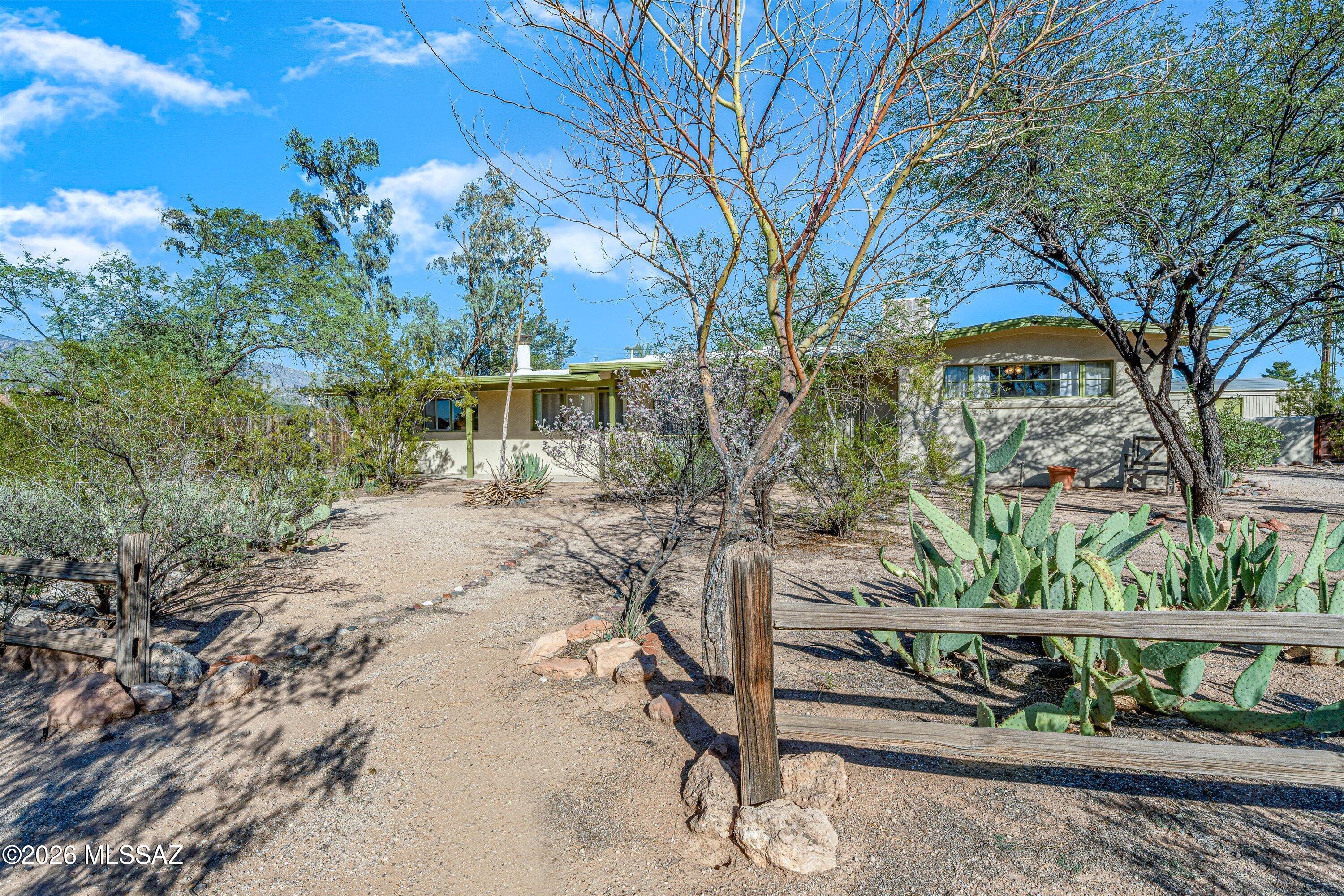 Richland Heights mid-century on a 1/3 of an acre checks many boxes.

This perfectly situated, low density, large parcel neighborhood is THE quintessential Tucson of yore.

Arrive to a sweet urban/suburban ranch with desert landscape and curb appeal that flows. Enter the living room to pristine, knotty pine paneling. Scan further to more fabulous features...concrete floors, framed vistas, and turn the corner...yes, a brand new, redesigned kitchen with backyard views!

This split floor plan features a spacious primary suite complete with focal fireplace, private backyard access, and, even, an antechamber! The second bedroom is so large it gives primary feels. An adjacent, updated hall bath retains period details. And the third bedroom makes this side like a separate wing. Out back a deep porch provides covered dining, lounging, and more. The fully fenced backyard with established landscape includes a free-standing studio before a custom drive gate and plenty of off-street parking.

This sought after, tucked away, prime location is convenient to shopping, dining, recreational and everyday needs. There is also easy access to: several hospitals, the University of Arizona, Raytheon, farmers markets and many parts of town. Much more to gush about here. Come, take a gander and grab this value rich turnkey opportunity!