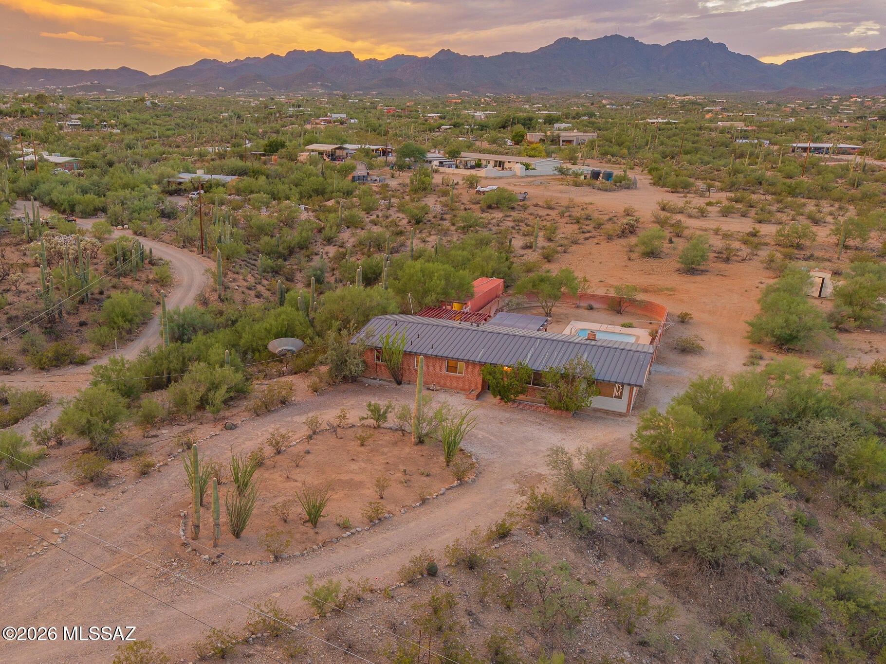 Rare opportunity to create your dream desert retreat on approximately three acres in Tucson's scenic west side. Surrounded by mature saguaros, this private property captures panoramic mountain views, colorful sunsets, and sparkling city lights. The expansive walled backyard features a swimming pool and extensive covered patio space ideal for outdoor living and entertaining. Inside, large windows, a brick fireplace, wood cabinetry, tile flooring, and a flexible bonus room provide a great foundation for renovation. With a metal roof, abundant storage, ample parking, and room for recreational vehicles, hobbies, or future improvements, this property offers the land, setting, and potential that are increasingly hard to find.