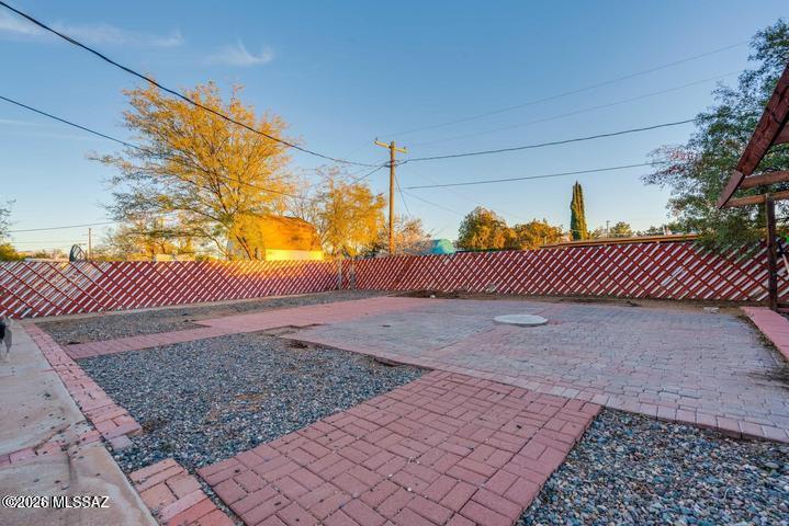 Displaying excellent curb appeal with palm trees and stunning mountain views, this property is conveniently located near Davis-Monthan AFB, restaurants, shopping, and offers easy access to I-10. Step inside to a welcoming foyer with vaulted ceilings, tile and wood-look flooring, a versatile den, and a cozy living room featuring a wood-burning fireplace. The formal dining room is perfect for gatherings, while the kitchen offers abundant wood cabinetry, tile countertops, breakfast bar seating, and direct patio access.

A spacious bonus room provides endless possibilities for a home office, game room, or hobby space. The three bedrooms and two bathrooms are generously sized and thoughtfully situated for privacy. The dedicated workshop area is ready for your next project or creative endeavor. Outside, unwind in the enclosed screened patio overlooking the expansive backyard, offering plenty of room for entertaining, gardening, or simply enjoying the outdoors.