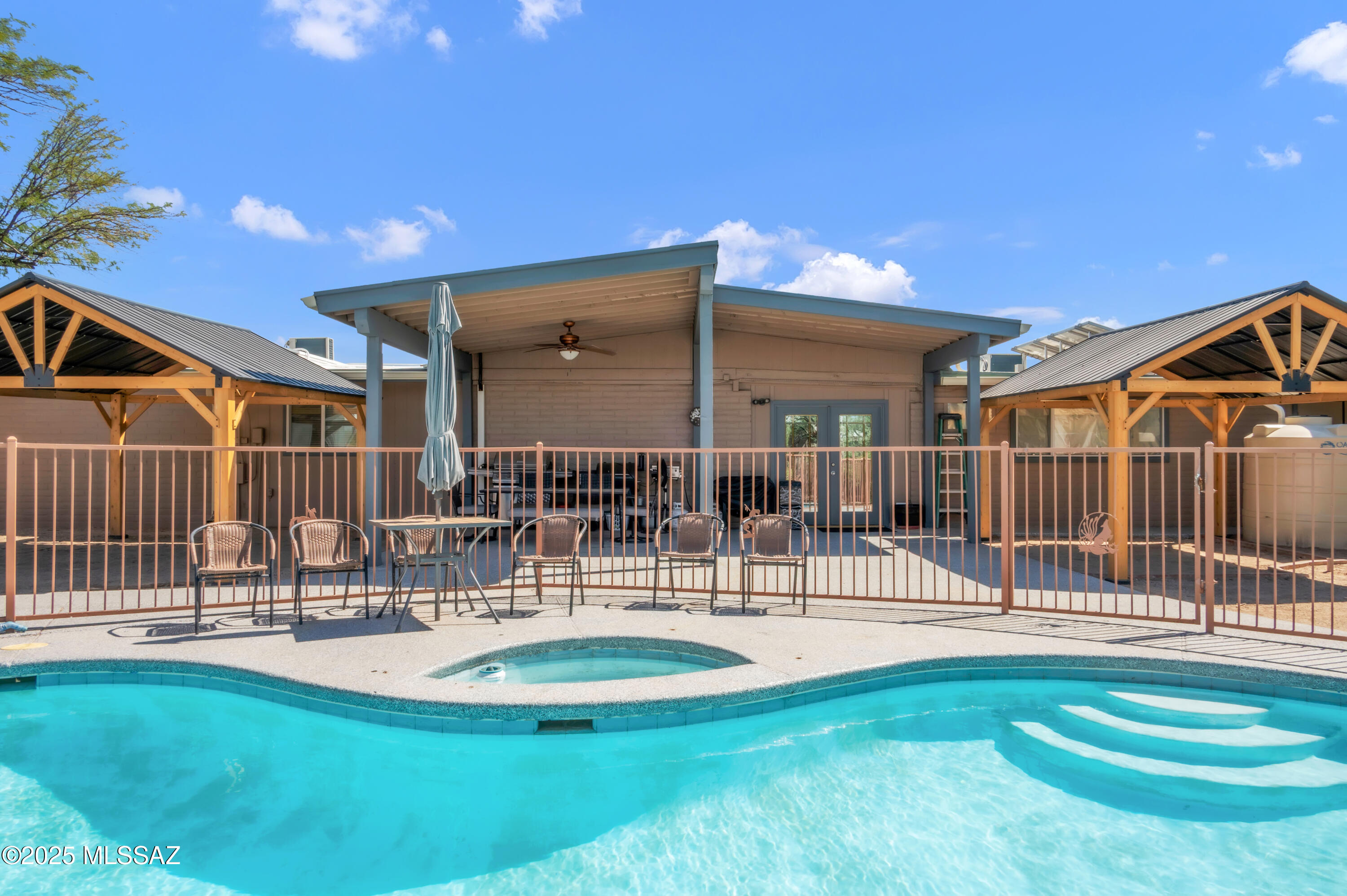 One-Of-A-Kind property in NW Casas Adobes Estates! This stunning home sits on a 1.24 acre corner lot w/ NO HOA & Pool! Inside enjoy 5bd, 4ba (including 3 primary suites). Perfect for multi-generational living, income potential, or anyone who loves space and versatility, designed to fit every lifestyle. Multiple living areas, relaxing atrium w/ water feature, & spacious kitchen with knotty alder cabinetry, tremendous storage including floor-to-ceiling built-ins, 2 pantries along w/ breakfast bar & dining nook. Two of the primary suites in the back wing are currently operating as Airbnb rentals (one includes private entrance directly to the room). The great room is equipped with a freestanding pellet stove fireplace & no carpet throughout the home. Primary suite includes updated bathroom, w/ walk-in shower, jetted soaking tub, dual sinks, walk-in closet, and private entrances to both the front & backyard. Outdoors, entertain or unwind under the covered patios, or cool off in the swimming pool. Fresh epoxy covers the pool deck, patios & walkways leading to the garage and pool/storage shed housing a new variable-speed pool pump, enclosed by a wrap-around block wall for added privacy. Detached 3-car garage has upgraded 30-amp electrical panel plus an additional adjoining storage room with loft. Enjoy a new 5-car covered front parking area, covered RV parking with pad and full hookups, chicken coop, plus additional acreage that provides endless potential and space for multiple trailers, RVs, and toys. Additional features include: 9,000-gallon composite cistern system equipped with three 3,000-gallon holding tanks around the home for rainwater collection with seamless gutters for flood control and overflow detection directed to irrigation. Fully OWNED solar (covering the power bill), brand-new whole-house mini split AC system, new roof within last 5 years, recently painted exterior. See Upgrade Sheet in Document tab for full list. With so many thoughtful upgrades and unique features, this property truly has it all. You need to see it to believe it, schedule your showing today!