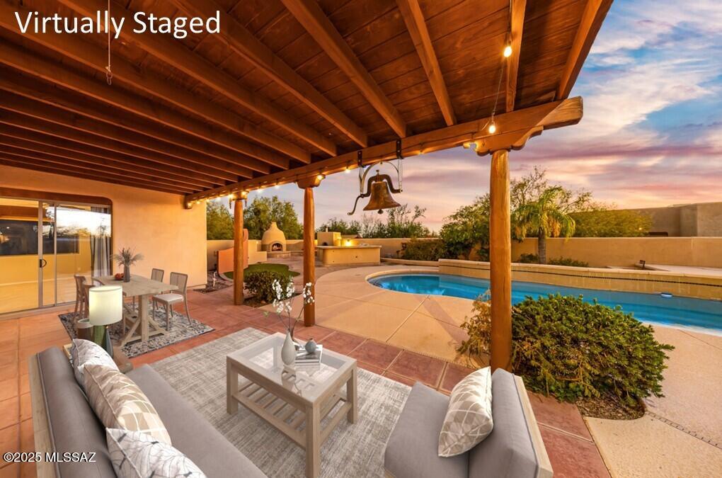 A rare find in Northwest Tucson! This exceptional Santa Fe estate on 1.1 acres w/no HOA offers versatility, privacy & unparalleled space for multi-generational living, car collectors, hobbyists or those seeking a true desert retreat. The 3,104sf main residence showcases timeless Southwest craftsmanship w/vega beams, custom tile work, soaring ceilings & expansive living areas designed for effortless entertaining w/inviting gated courtyard. Open kitchen & family room feature hickory cabinetry, granite countertops, large walk-in pantry, breakfast nook & sliding doors that lead to the inviting backyard. Formal living & dining area adds flexibility for gatherings of any size. Split-bedroom layout includes 4 spacious bedrooms plus a dedicated office w/built-in desk Primary suite offers a luxurious escape complete w/jetted tub, separate walk-in shower, dual vanities & generous walk-in closet. Additional conveniences include laundry room w/cabinetry & included washer & dryer, a powder room & 3-car oversized garage. The 912sf guest house is a standout feature ideal for extended family, visitors or rental possibilities. With a fully equipped w/kitchen, living area, bedroom & bath has its own 1-car garage plus an extended RV garage plus an observation deck to take in breathtaking sunsets & star-filled skies. The backyard is like your own personal resort w/sparkling pool & spa, surrounded by Kool decking and flagstone, outdoor kitchen, wood-fired pizza oven, kiva fireplace & charming ramada for shaded gatherings. Multiple covered and uncovered patios invite relaxation year-round. With newer A/C units & roofing (2023), solar-heated pool, room for horses & endless storage for vehicles & toy  this one-of-a-kind home checks every box. A truly special property, versatile, beautifully crafted & ready to fill the needs of a wide range of buyers. Come explore the possibilities.