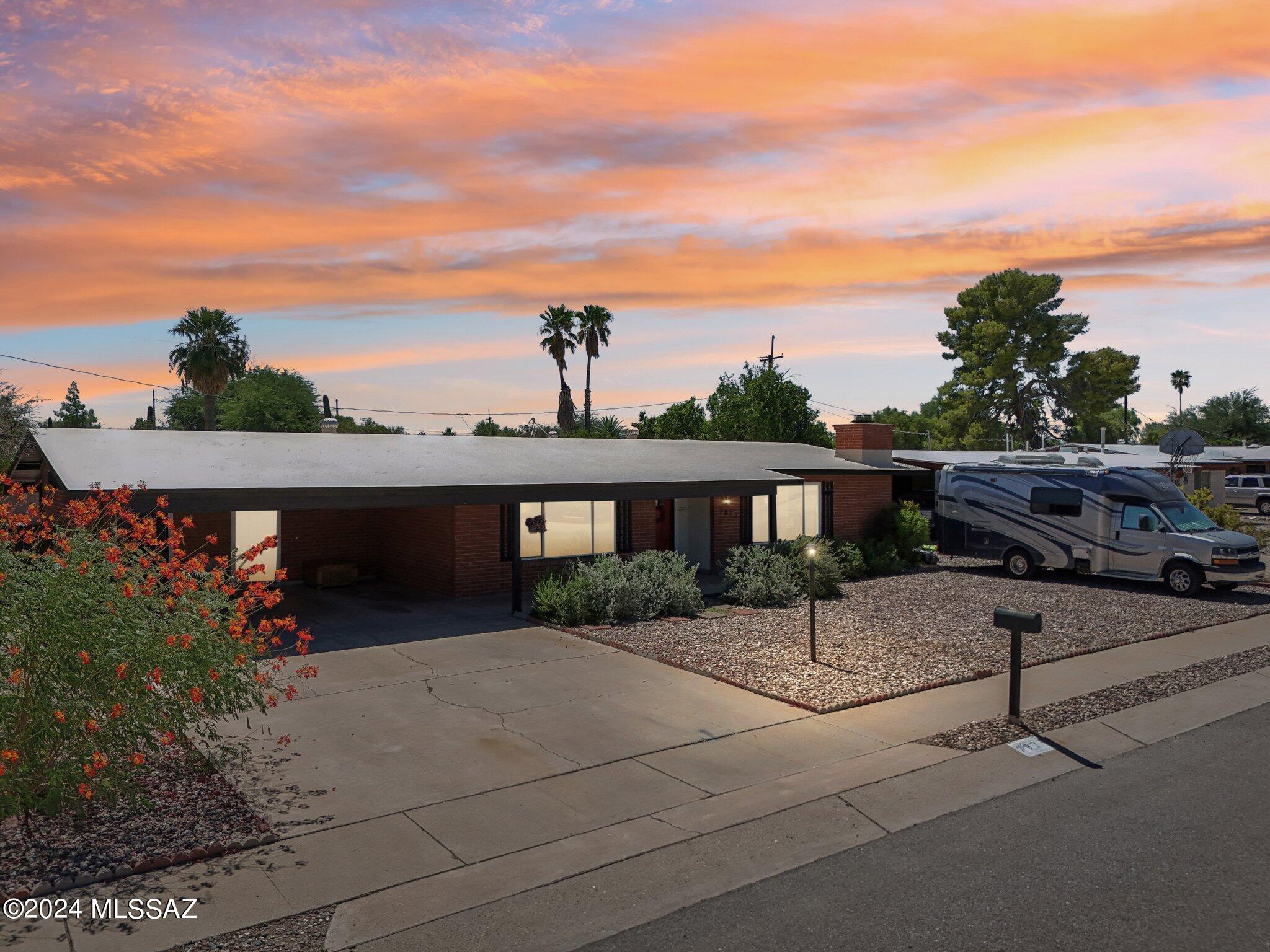 This beautifully remodeled mid-century brick home has everything you've been searching for, blending timeless charm with modern updates. The kitchen, remodeled in 2020, features sleek white cabinets, quartz countertops, and a chef-level 6-burner gas stove with a stainless steel exhaust fan, perfect for culinary enthusiasts. The office/flex room offers a cozy retreat with a wood-burning fireplace. The great room, located off the kitchen, is the ideal spot to relax, with stunning mountain views and a clear view of the large, heated pool. Outside, enjoy the new outdoor fan under the patio, or cool off under the gazebo equipped with misters. Additional upgrades include a newer Goettl A/C and a recently recoated roof. The property also includes two backyard sheds for extra storage and all appliances, making this home move-in ready and perfect for those who appreciate both style and functionality.