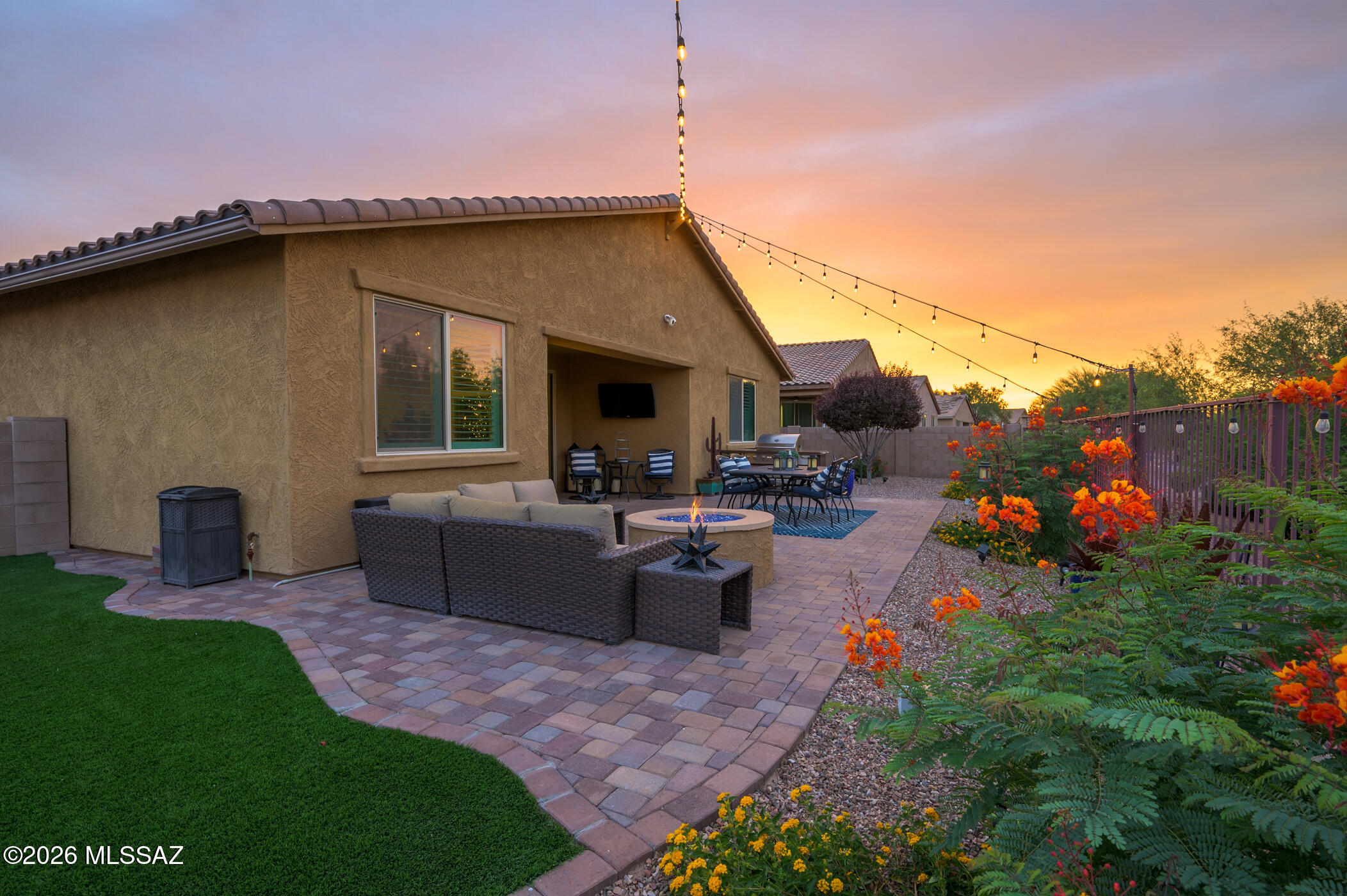 Welcome home to the perfect blend of space, style, and location! This beautifully maintained 4-bedroom, 3-bathroom home with an impressive 4-car garage offers a versatile floor plan designed for the way you live today. Step inside to find extended tile flooring, designer touches, and picture-perfect spaces throughout. At the front of the home, two secondary bedrooms share a convenient Jack-and-Jill bathroom, while a separate bedroom and full bath near the entry create the ideal setup for guests, multigenerational living, a private office, or next-gen lifestyle needs. The heart of the home is the gourmet kitchen featuring abundant cabinetry, generous workspace, a breakfast nook, and easy access to the formal dining room. The dining space offers flexibility as an additional living area, game room, or whatever best suits your lifestyle. Between the kitchen and dining area, you'll find a charming upgraded coffee bar station ready for morning routines, entertaining, or creative use. A bonus flex space currently serves as a wine room but could easily become a pocket office, hobby room, homework station, or personalized retreat. The spacious laundry room includes built-in cabinetry for exceptional storage and organization. Outside, your private backyard oasis awaits. Enjoy low-maintenance turf, a cozy gas fire pit, and a top-to-bottom view fence showcasing breathtaking mountain views, colorful Arizona sunsets, and no rear neighbors. Backing directly to Compass Park, you'll enjoy an open, expansive feel that's hard to find. The location is just as impressive. Walk to Fry's Marketplace, restaurants, coffee shops, and new businesses while enjoying easy access to The Loop trail system, community parks, a large splash pad, soccer fields, baseball fields, dog parks, and endless opportunities for outdoor recreation. Homes that combine a flexible floor plan, 4-car garage, premium views, and this level of convenience rarely come available. Schedule your private showing today before someone else calls it home!