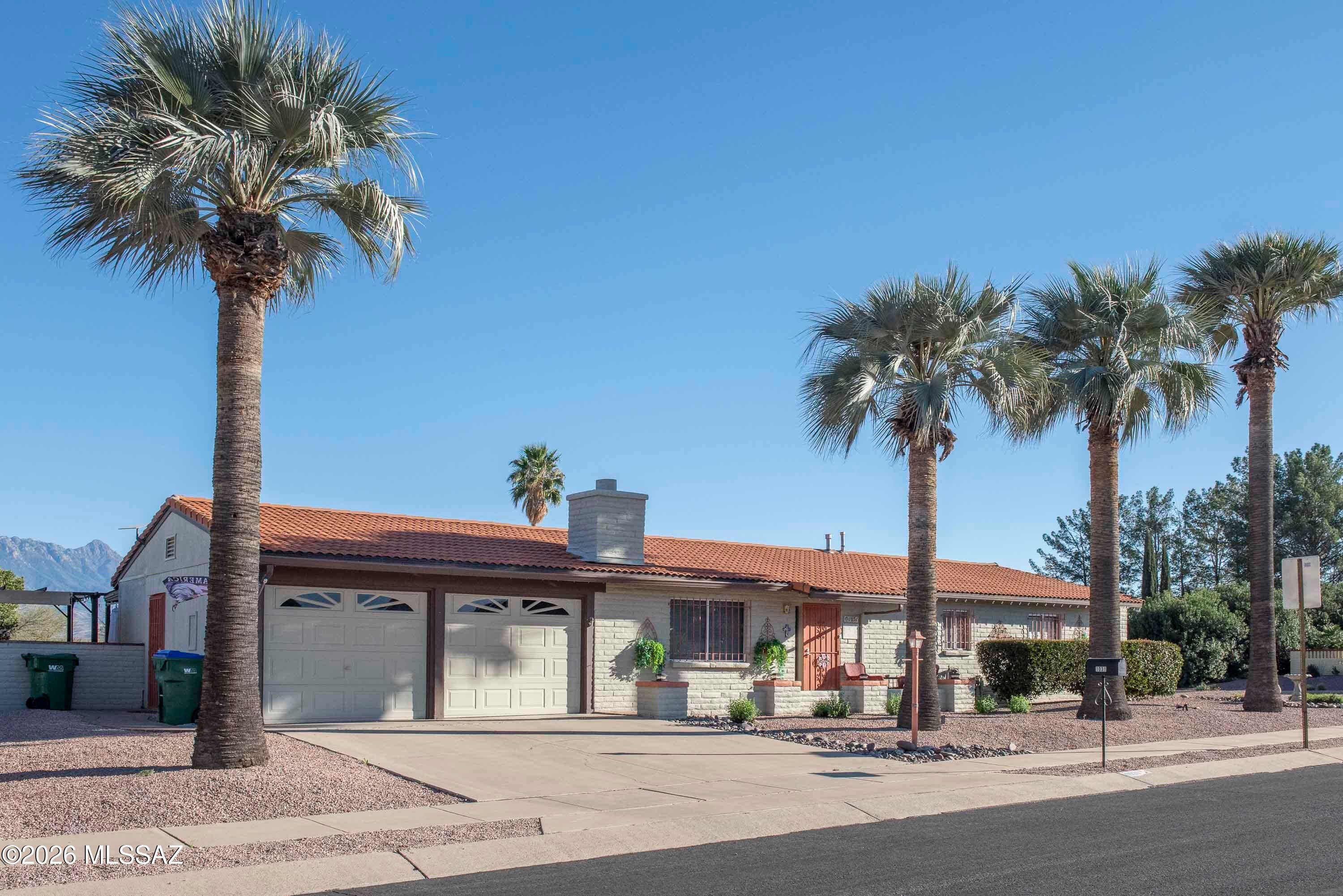 Welcome to paradise! Right by Desert Meadows Park this charming 3 bed, 2 bath corner lot home with 2 car garage, indoor laundry (extra storage and sink), gas fireplace, enclosed porch (with window AC/heat), renovated pool (2025) and views! As the model for this 55+ community the home was stretched 8' giving extra space in the Master and Guest Bedrooms. Extensive renovations (2016) include new roof, wiring in kitchen and laundry, electric panel, HVAC, kitchen, flooring, security gates (doors/windows). Bathrooms feature hand-painted tiles and sinks. Low-maintenance yard offers turf grass, a custom water feature and shaded seating areas to enjoy the views of local pecan orchards and the Santa Rita Mountains. Drip system front and back. Low HOA. GVR not included but available.