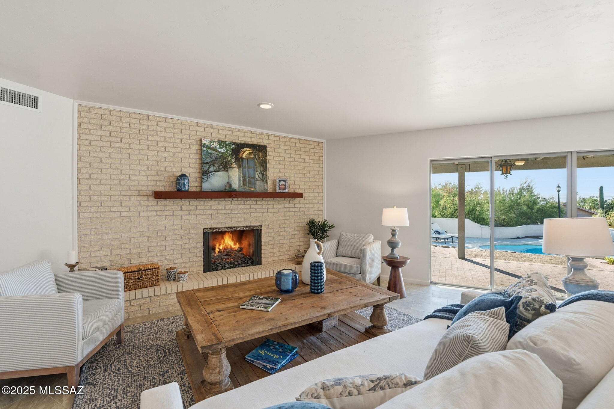 Beautiful home in Shadow Roc neighborhood of the Catalina Foothills, this modern territorial-style residence blends timeless charm with contemporary comfort. Built in 1973 and thoughtfully updated, this single-level home offers 3,152sq. ft. of bright, open living space with three bedrooms and three bathrooms. Step through the inviting foyer accented by stained-glass windows into a home designed for both relaxation and entertainment. The formal living room captures breathtaking views of Pusch Ridge Wilderness of the Santa Catalina Mountains, while two wood-burning fireplaces add warmth and ambiance throughout. The home's chef-inspired kitchen is a true delight, featuring granite countertops, stainless steel appliances, double ovens, and abundant storage. The spacious primary suite offers a