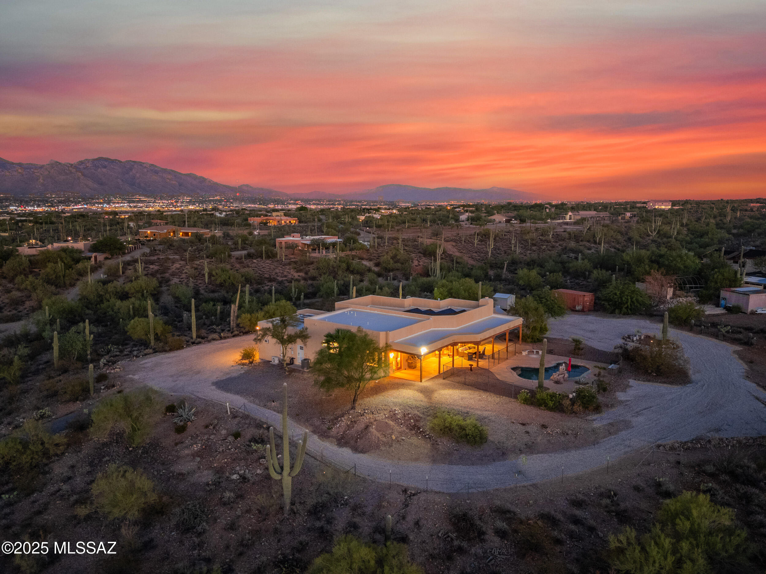 Perched atop a private 4.14-acre hilltop parcel, this exceptional residence offers breathtaking panoramic views of surrounding mountain ranges, stunning sunsets, and sparkling city lights after dusk. Located in scenic, Saguaro-studded Westside Tucson, this property blends natural beauty with elegant comfort—and welcomes your horses, too!

Thoughtfully designed for relaxed, yet refined living, the three bedroom, two and a half bath floorplan features an open concept living space anchored by a fireplace and picture windows that frame the ever-changing sky. The spacious kitchen is outfitted with generous cabinetry, a center island with breakfast bar and triple-bowl sink, easy-care Silestone counters, stainless steel appliances (including a gas range and additional wall oven) and a convenient built-in desk.  
The private primary suite is a retreat of its own, with a tranquil sitting area that captures sweeping vistas and provides direct access to the outdoors. The spa-like bath includes a vessel tub with a chic tile rug underneath, a beautifully tiled walk-in shower, dual vanities and a separate toilet room. Two walk-in closets off the bathroom offer abundant storage.

A formal dining room and versatile den/flex room are located just off the entry and showcase sweeping views. Both rooms could be utilized in whatever ways suit your lifestyle.

Outdoors, the extended covered patio invites al fresco dining and shady relaxation. Dip in the refreshing saltwater pool on a hot day or swim under a blanket of stars on summer evenings. The backyard has views of the Tucson Mountains, which are strikingly silhouetted at sunset. A large side yard has room for an RV, a garden area with garden boxes already installed and offers a myriad of possibilities.
Out front, panoramic views of the desert and city allow for a feeling of openness and freedom that is part of the Southwest's signature style. This property allows you space to breathe deeply and enjoy the wildlife, while still close enough to the I-10 and amenities for convenience. There is no HOA and plenty of room for horses!
Additional features of this property include a 30-panel solar array, a water conditioning system, and a 50-amp RV hookup and drains. The garage includes a mini-split climate control system and convenient exterior access.  A portion of this property (located across the road) has been cleared and is ready for use as you see fit.