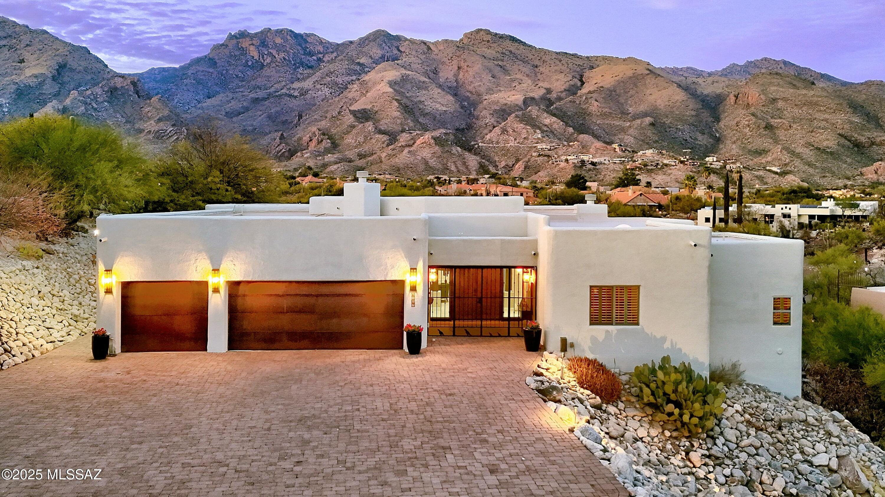 Views, Views, Views! Experience luxury living in this stunning contemporary home, perfectly situated on a private acre lot to capture the breathtaking views of the Catalina Mountains, Rincon Mountains, Mount Lemmon and even a peak of the Tucson city lights.  

This architectural masterpiece blends modern elegance with the natural beauty of its surroundings, creating a home that is both stylish and serene. Natural light, high ceilings, and oversized windows flood every room, enhancing the open and airy feel of the home.  

The modern kitchen is a chef's and entertainer's dream with high-end appliances, double oven, a spacious island, and sophisticated finishes.  It opens to a large great room with an unobstructed mountain view. The split floor plan offers privacy and functionality with generously sized bedrooms, including a luxurious primary suite.  Three fireplaces add warmth and ambiance, while spa like bathrooms offer the ultimate in relaxation.

The outdoor living area is the true showstopper.  The infinity-edge pool (heated) appears to blend into the Catalina mountains for a picture-perfect backdrop.  The outdoor kitchen, complete with built in grill, refrigerator, sink, and granite sitting area makes entertaining effortless.  The gas firepit, outdoor tv, and beautifully landscaped backyard provide the ideal space to unwind quietly or with friends.

Additional features include a newly coated roof with a transferrable warranty, new windows, and 24/7 on-site mobile security that provides daily house checks when you are away, offering peace of mind and convenience.

This home offers unparalleled luxury, incredible views and a lifestyle that's second to none!