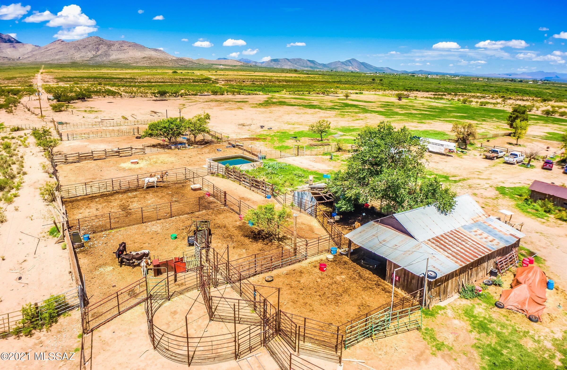 LET THE PREVIOUS BUYERS BREACH BE YOUR GAIN! Working Cattle Ranch at the road's end that backs up to the Dragoon Mountains, featuring 10,000+ acres (~600 Ac Deeded, ~2,100 Ac State Lease & ~7,500 Ac USDA Grazing Permit). 10,000 Gal concrete water storage tank, automatic watering, 2 private registered wells (including 1 irrigation well of ~1,200' deep w/ 3-phase power) & side roll irrigation equipment. 8 pens/corrals w/ squeeze chute, 3 pastures, plus additional enclosed areas equipped to contain livestock. Several outbuildings, including ~1,560 SqFt (~60' x 26') metal hay storage building/livestock shelter that could also serve as covered parking for vehicles/equipment. Lovely mature trees surround the rustic 1,783 sqft home. Home & Well Inspection reports available to QUALIFIED buyers.