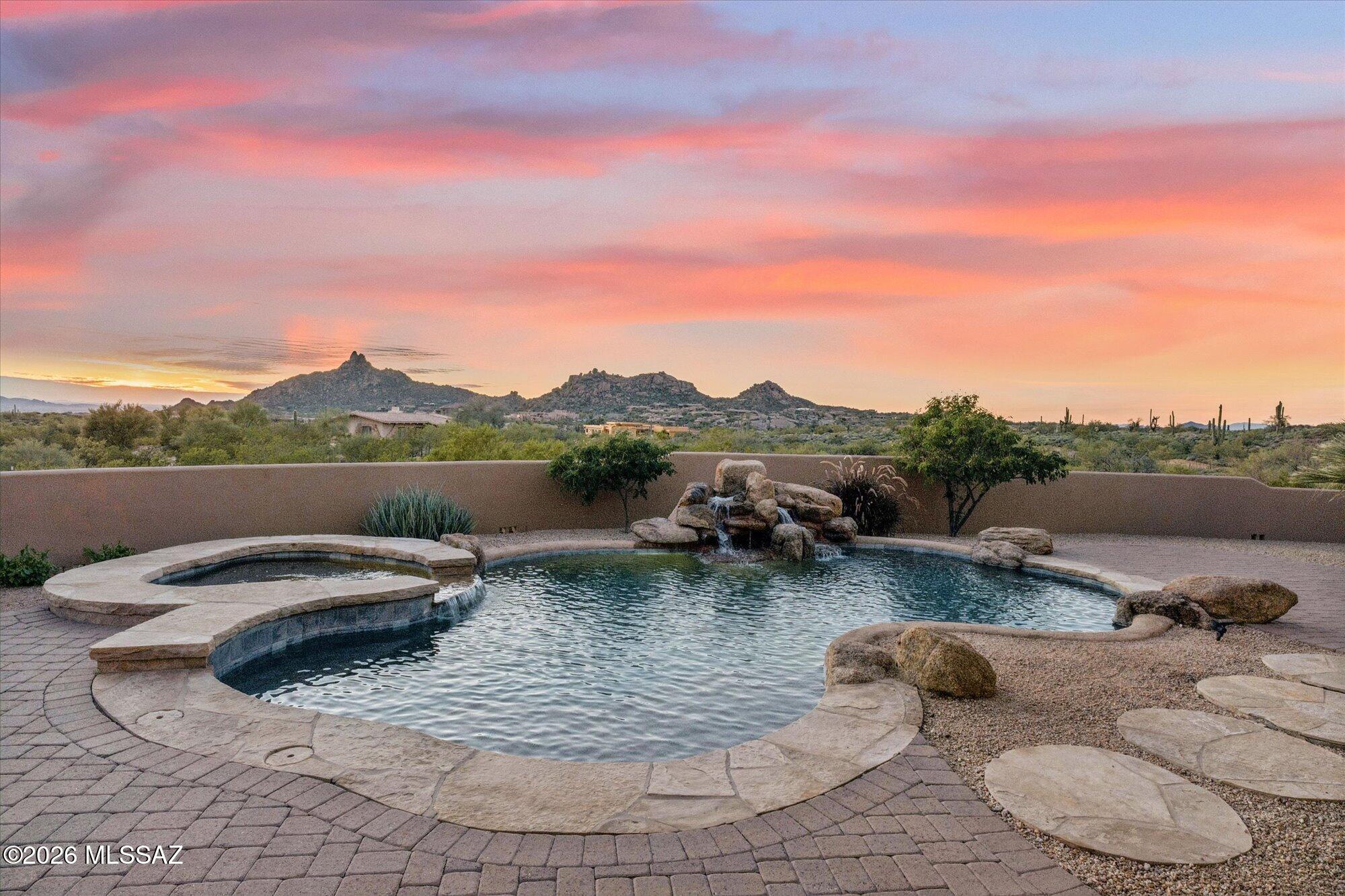 ust updated 5,300+ sq.ft. luxury home in gated community on 2.6 acres! 4 bedroom, 5 bath estate situated in the community of Desert Summit. This exceptional Scottsdale home captures the beauty of the Sonoran Desert with timeless design and effortless indoor/outdoor flow. The spacious great room features high ceilings, custom finishes, and elegant stone and wood details. A gourmet kitchen and private ensuite bedrooms offer comfort and style, while outdoor living areas showcase stunning views of city lights and iconic Pinnacle Peak. Designed for both entertaining and relaxation, this residence combines sophistication, warmth, and a true desert-luxury lifestyle. Additional features include stone lined walking paths on the property, long bricked driveway on a hidden flag style lot. PRIVACY