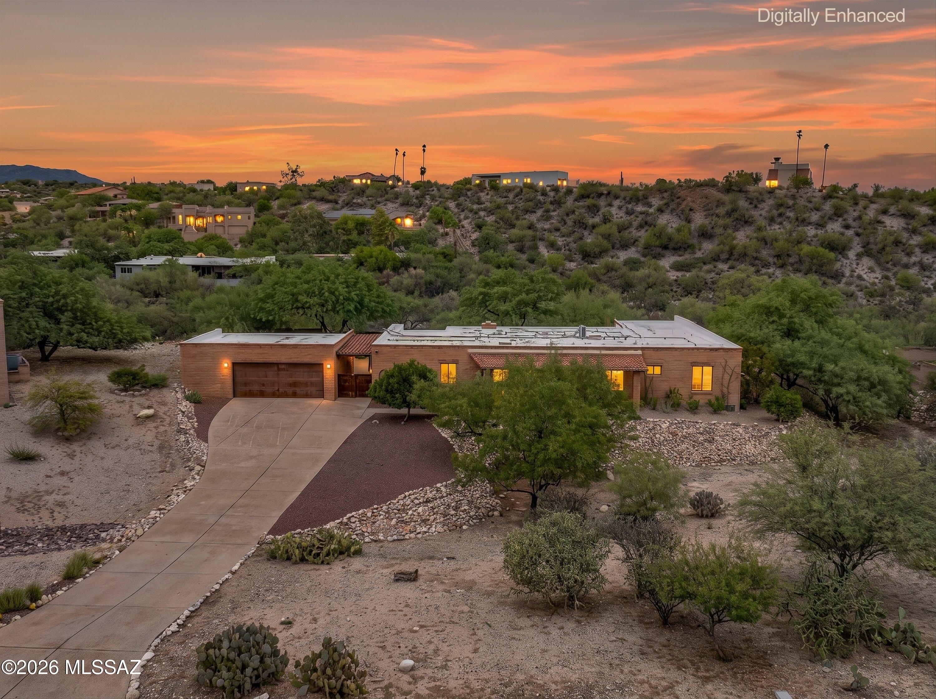 Set on a private .74 acre lot in the highly desirable Foothills, this Southwestern-style home backs to natural open space with a scenic arroyo and stunning mountain views. The 2,681 sq. ft. floor plan features low maintenance concrete floors, a formal living room with fireplace, separate family room, formal dining area, and multiple sliding doors that create seamless indoor/outdoor living. The updated kitchen offers stainless steel appliances and a gas range, while the bathrooms have been tastefully renovated. Step outside to an expansive covered patio, elevated view deck, built-in BBQ, raised vegetable gardens, and plenty of space to add a pool. Enjoy breathtaking mountain views from both inside and out. Additional highlights include a separate laundry room, fresh interior paint, and a newly coated roof, new tile roof, and new roof on the garage.