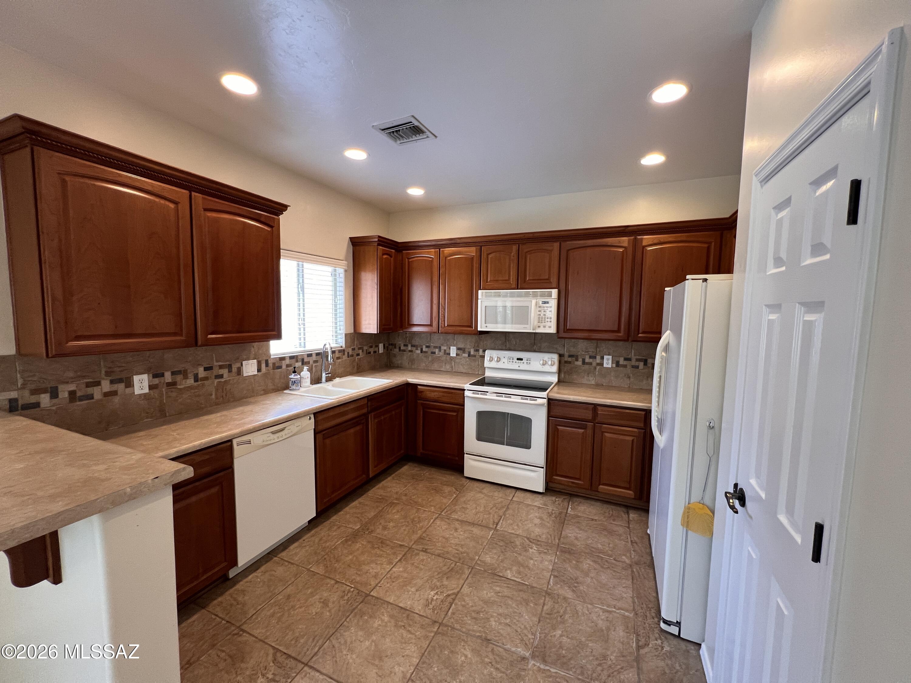 This desirable 4 bedroom, 2 1/2 bath home is nestled in a quiet neighborhood near schools, parks, library, shopping (Costco/Walmart), minutes from freeway access, and only 3.5 miles from the U of A. Built in 2006, the home features a big open kitchen, living room, den and 1/2 bath downstairs, tile flooring, carpet in the living areas, laundry room w/ hookup, two car garage, and covered patio. The master suite includes a separate sitting room and large bathroom with shower, double sinks, and big walk-in closet.