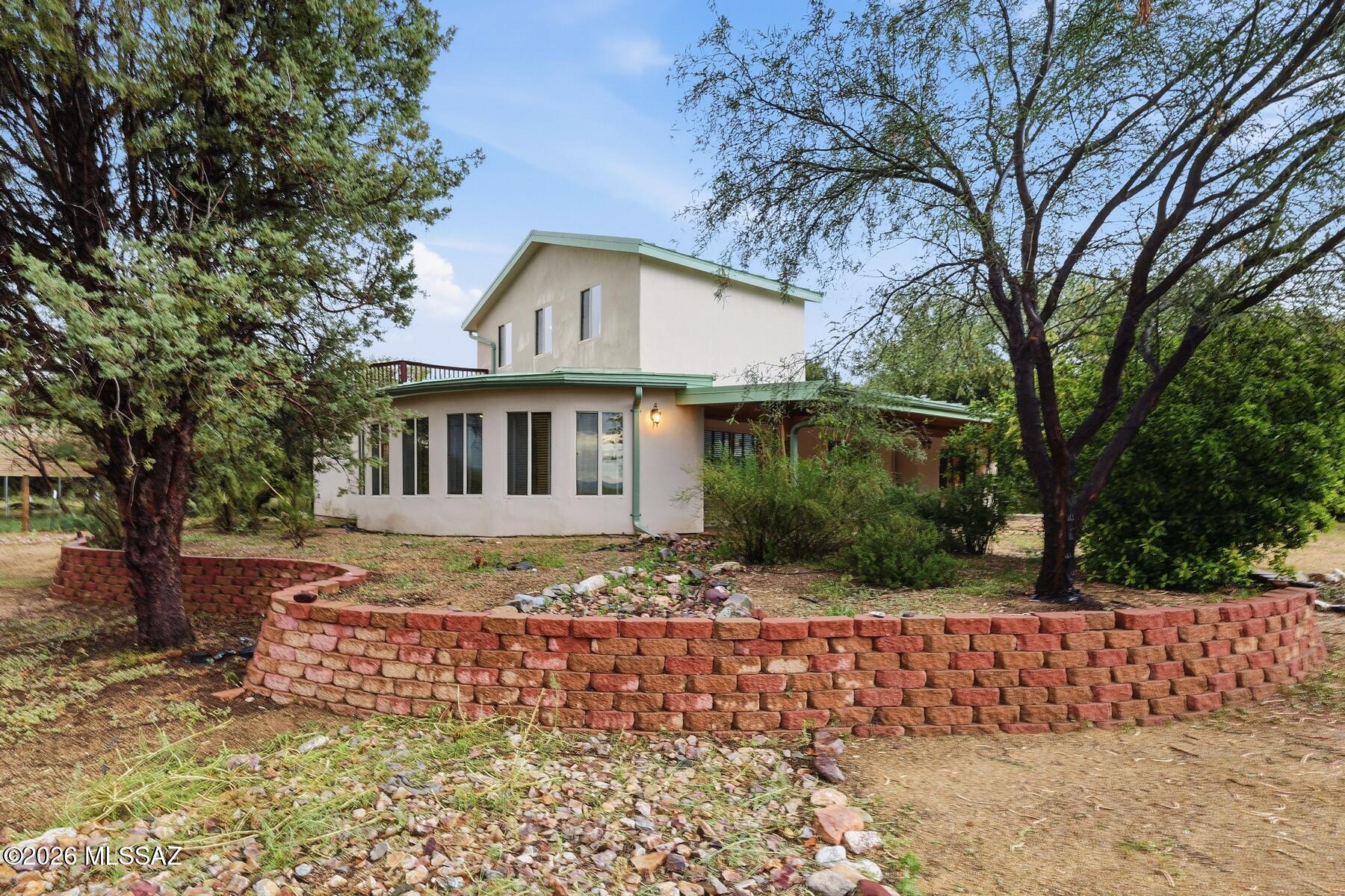 Escape to 4.19 acres in beautiful St. David, AZ! This unique 2-story rammed earth home offers 2,031 sq ft of living space with 2 bedrooms, 1 bath, an upper deck, and a large covered porch perfect for enjoying Arizona sunsets. Enjoy a striking moon-shaped Arizona room and a dedicated entertainment/media room for relaxing or hosting. Mature, shady mesquite trees shade the irrigated grounds, with the St. David Ditch running through the property. A private well, drilled to 600 ft with water at a shallow 100 ft depth, adds water security. Horses are welcome, with covered RV parking, a 4-car garage, a carport, and two shipping containers for storage. Convenient paved road access, just 10 minutes from historic Tombstone. Zoned R-36, with options to subdivide.