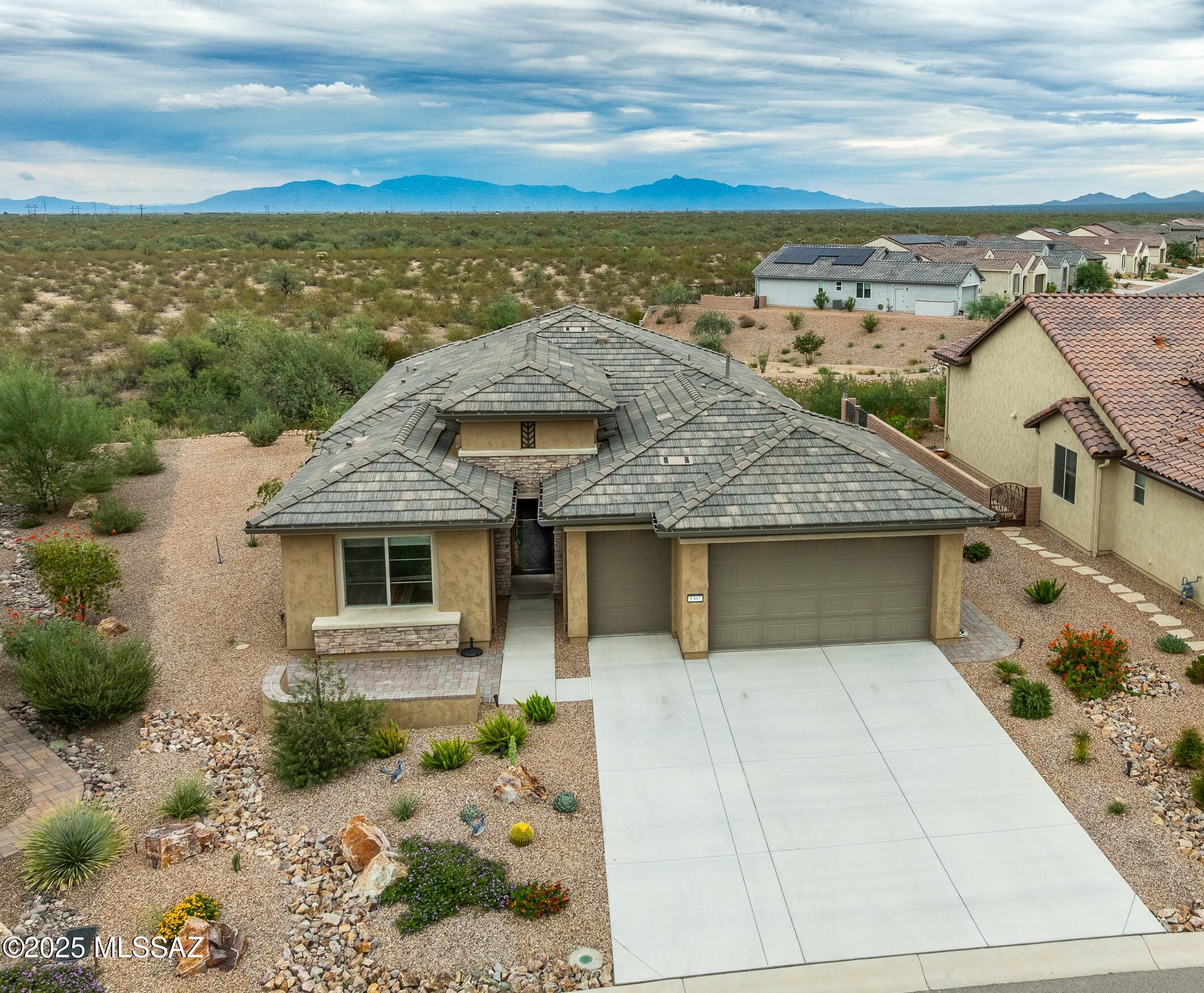 Infinite views over the desert to the Catalina & Rincon Mts. on this premium lot in Quail Creek. A customized Robson Mariposa model with several upgrades! 4' extended owners suite, high ceilings, dual pane windows for the 180 degree views of the desert, and Catalina & Rincon Mts. Quartz countertops  thruout the home. High ceilings, walkin pantry, Built in Coffee Bar and wine cooler in the fabulous great room. Entertain guests in the covered  brick paved patio with a water feature and  miles of views! The landscape is low maintenance, so you can also enjoy your home.