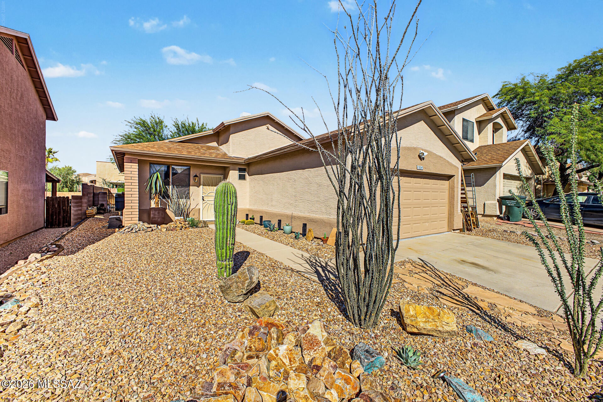 VA assumable loan at 2.875% interest rate! This lovely 3-bedroom, 2-bath home showcases a 2-car garage and a low-maintenance desert landscape. Inside, you'll find an inviting living room with vaulted ceilings, a neutral palette, blinds, and stylish wood-look flooring. The eat-in kitchen comes with crisp white cabinetry, a mosaic tile backsplash, sleek stainless steel appliances, and a handy pantry for storing culinary essentials. The primary bedroom includes soft carpeting, sliding door access to the backyard for seamless indoor-outdoor flow, a private bathroom, and a practical walk-in closet. Spend peaceful afternoons in the backyard, which offers a covered patio and a mature Mesquite tree for natural shade. Don't miss your chance to own this charming property!