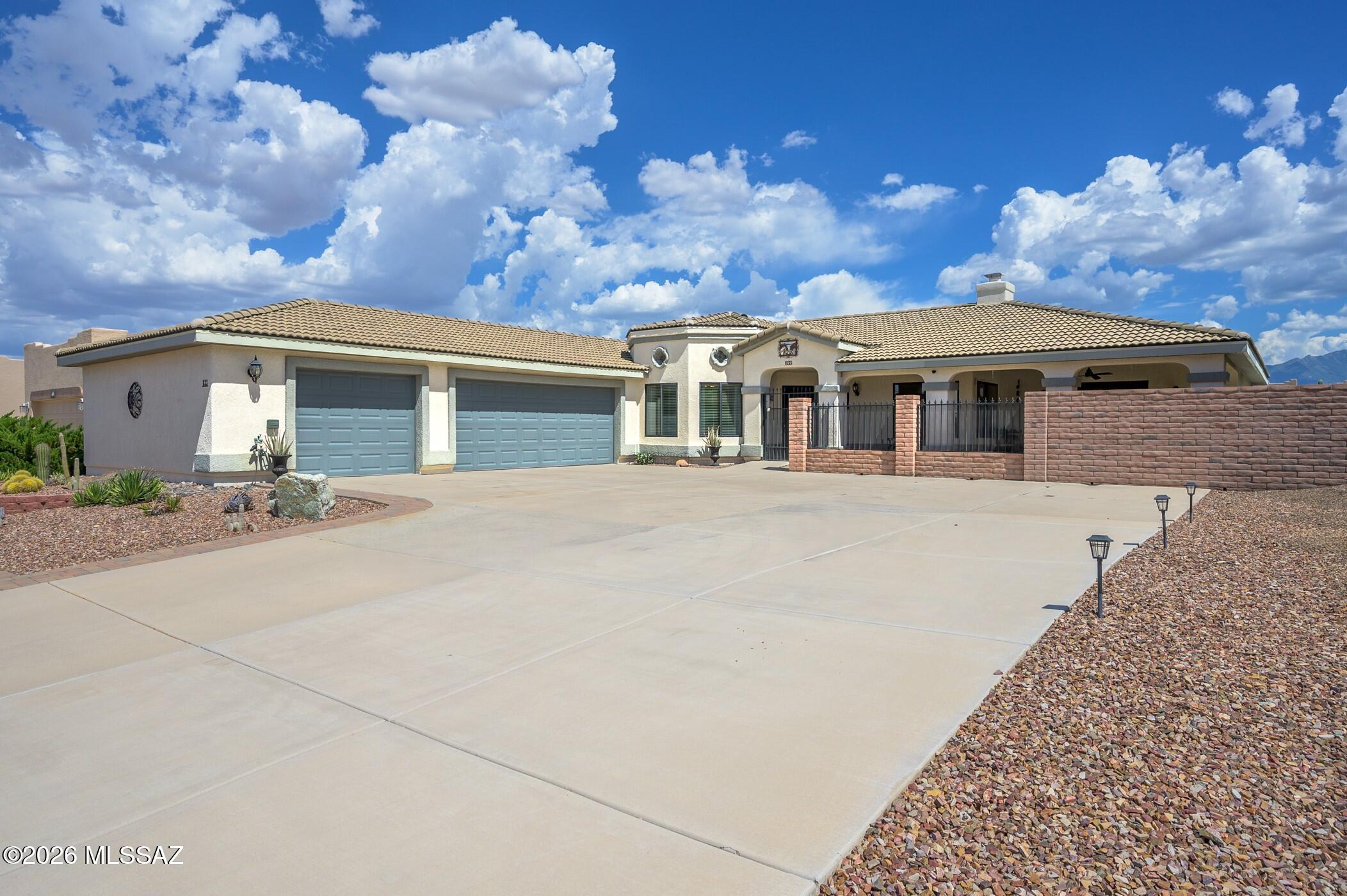 Experience an unparalleled retirement lifestyle in the highly desirable Portillo Ridge community nestled in the picturesque landscape of Southern Arizona. This exceptional, custom-built residence is a standout both in design and functionality, beginning with its charming gated front courtyard. The courtyard offers a series of delightful seating areas, providing serene spots to relax and soak up the warm Arizona sunshine, making it ideal for morning coffee or evening gatherings with friends and family. Upon entering the home, you are greeted by exquisite Southwest tile flooring that flows seamlessly throughout the living spaces. The soothing color palette enhances the inviting atmosphere, while vaulted ceilings impart an airy openness that makes the interior feel even more spacious. The living room features an enchanting gas fireplace with a custom brick hearth, adding an element of elegance to the space and making it perfect for relaxation or entertaining guests. Adjacent to the living room, the dining area is designed for versatility, easily transitioning into a home office or extra flex space to accommodate your personal needs. Whether hosting dinner parties or working from home, this area makes the most of your available space. A true culinary masterpiece, the kitchen dazzles with exquisite hickory cabinetry that offers ample storage, a high-efficiency gas cooktop for precision cooking, and a built-in wall oven that makes meal prep a breeze. The stunning granite countertops not only enhance the kitchen's aesthetic appeal but also provide generous workspace for culinary creations. Sufficient recessed LED lighting brightens the area, ensuring that every corner of this kitchen shines. The thoughtfully designed split floor plan adds a layer of privacy for guests, with guest rooms nestled comfortably in the home's west wing. Your expansive primary suite is a personal retreat, complete with a luxurious bathroom featuring an indulgent walk-in tile shower and a rejuvenating jetted tub, perfect for unwinding after a long day. Step outside to discover an equally remarkable outdoor living space, where you can entertain beneath an extended aluminum Ramada. This versatile area is perfect for cozy movie nights, watching your favorite sports teams, or simply enjoying intimate dinners under the stars. For golf enthusiasts, the property offers a private putting green, allowing you to practice your swing in the comfort of your own backyard. The easy-care landscaping surrounding the home is both practical and appealing, with designated areas for raised bed gardening, inviting you to cultivate a variety of blooms, herbs, and vegetables. An oversized three-car garage adds convenience by providing ample room for vehicles, hobbies, and additional storage. As a resident of this vibrant community, you will have full access to the numerous activities and clubs offered by Green Valley Recreation, ensuring that every day is filled with opportunities for social engagement and active adult living. This home truly embodies the essence of a fulfilling retirement experience, making it a remarkable place to call home!