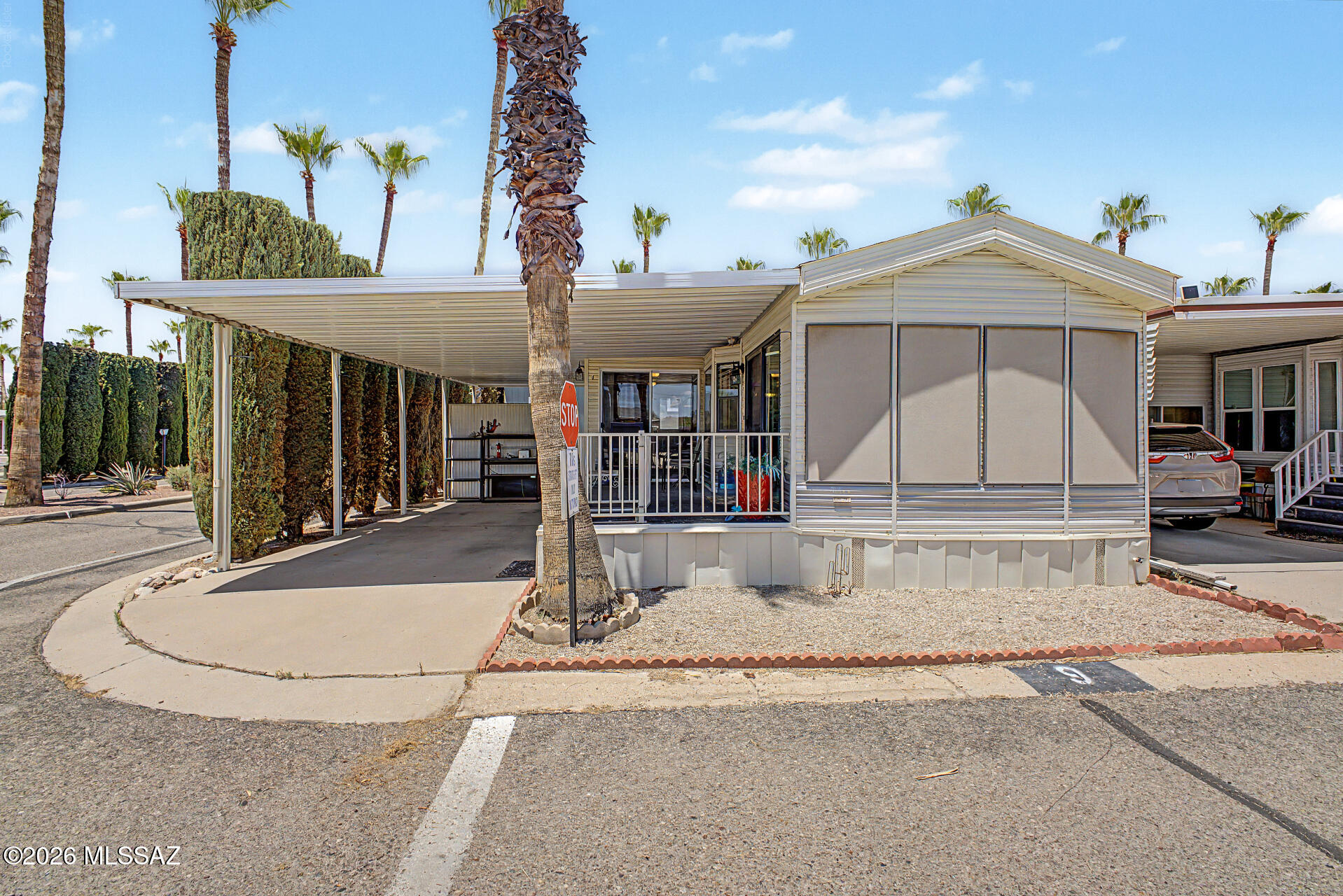 Discover this charming manufactured home, perfectly situated on a corner lot in Rincon Country! Discover carport parking, sunscreens, and a welcoming porch. Step inside to vaulted ceilings, a blend of carpet and laminate flooring, and a living/dining room. The kitchen boasts built-in appliances and ample storage. The bedroom offers mirrored closet doors, while the bathroom features a granite vanity. A sizable family/AZ room offers a cozy space for entertaining. A back patio door leads to a detached storage room with washer hookup. This gated 55+ RV community offers  resort living, with endless activities and amenities! Enjoy a community center, pool, spa, exercise facilities, arts and crafts rooms, and a woodworking center. Come see this delightful home!