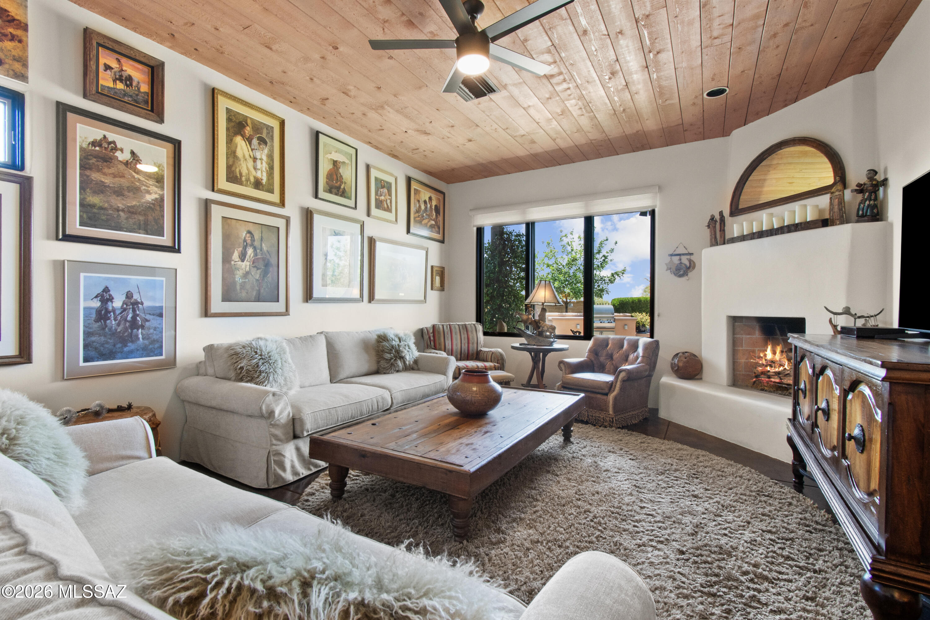 THIS is the home that oozes true Tucson charm. Designed by builder Stellar Gray, this semi-custom ICF with adobe accents sits inside gated Sky Ranch. The front porch greets you with a sitting spot to marvel at the Catalina mountain view. Step inside onto polished concrete floors and 10 1/2 foot tongue and groove pine ceilings. The perfect reading room welcomes you to cozy up for the upcoming monsoons and listen to the rain when it hits the metal roof. The floor plan flows effortlessly into the kitchen where you find quartz   countertops and island, Viking brand gas range, refrigerator and microwave along with a Bosch dishwasher, and stainless farm sink. Dining area is large enough for the gatherings and holidays and the family room with the Rumford fireplace is where stories will be told. Bathrooms have copper sinks and Talavera tile surrounds that will remind you of Old Mexico. Split bedroom layout gives everyone their own peace and quiet. Primary suite sits in the back of the home with a sanctuary feel. Walk in closet, soaking tub, separate shower and double vanity. 
Backyard feels like you are walking out to the "spool" of a local ranch resort. Flagstone, artificial turf and the perfect cooling spot, waterfall included. Built in gas BBQ, covered patio and those famous Tucson sunsets. If you are tired of cookie cutter and want to live your Tucson experience, this is the home for you.