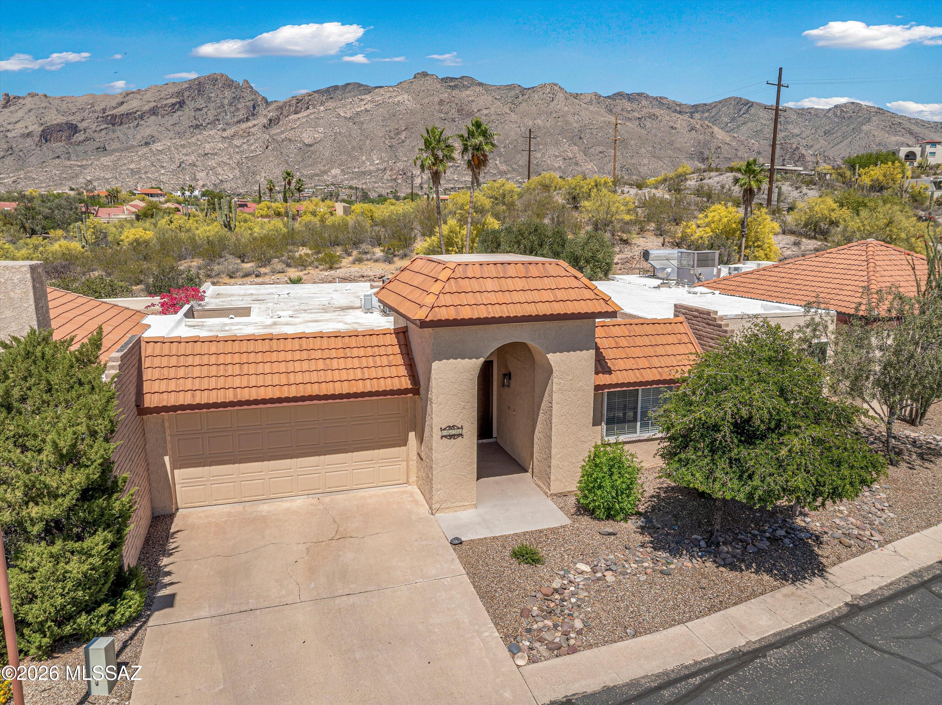 Experience refined desert living in this beautifully appointed Catalina Foothills townhouse with breathtaking mountain views.  This low-maintenance Northern Tucson property features an open split bedroom floor plan with private atriums providing an abundance of natural light, engineered hardwood flooring, HVAC replaced in 2023 and electric water heater in 2025, updated recessed lighting & ceiling fans, low care North facing backyard with brick paver patio and desert / mountain views, secluded primary bedroom with roomy walk-in closet, both bathrooms have been remodeled, eat-in kitchen with Corain counters and a convenient location near shopping & restaurants. HOA amenities include 2 pools & 1 hot tub, gym, resurfaced pickleball / tennis & basketball court, playground & clubhouse.