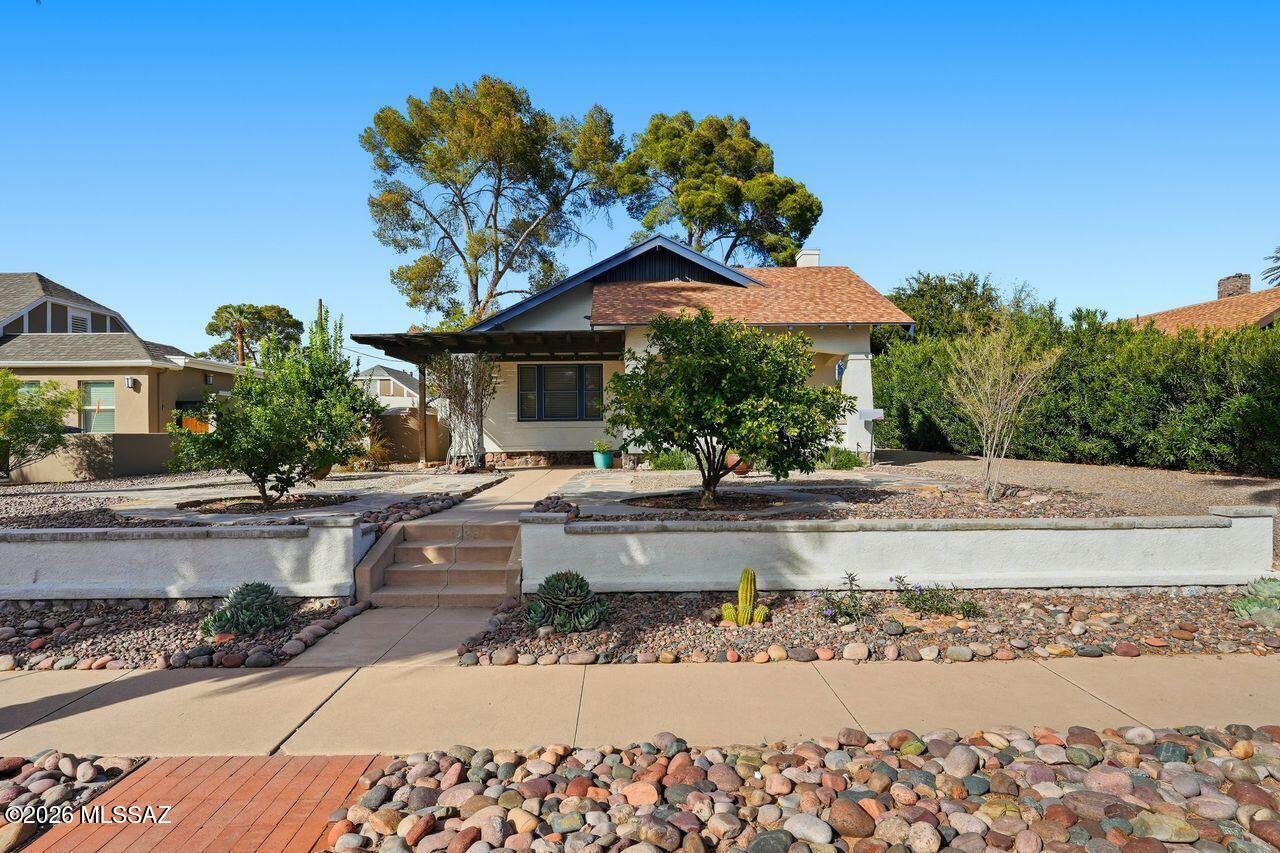 Perched on an elevated lot on 4th Street in historic Sam Hughes, just one block from the University of Arizona campus, is this darling 1923 bungalow that has both curb appeal and an amazing interior.  The main house has two large bedrooms, two baths, generous living and dining rooms, and a finished basement, complete with a mini-split, that's perfect for a den or office.  The beautiful finishes throughout make it a very inviting space to come home to.  The guest studio has its own washer/dryer, kitchenette, mini-split and fenced yard. The property owner currently receives a historic property tax rate for a primary residence.  A new central heating and cooling system was just installed, and the 10-year warranty transfers to the buyer.  This charming home in a great location awaits you!