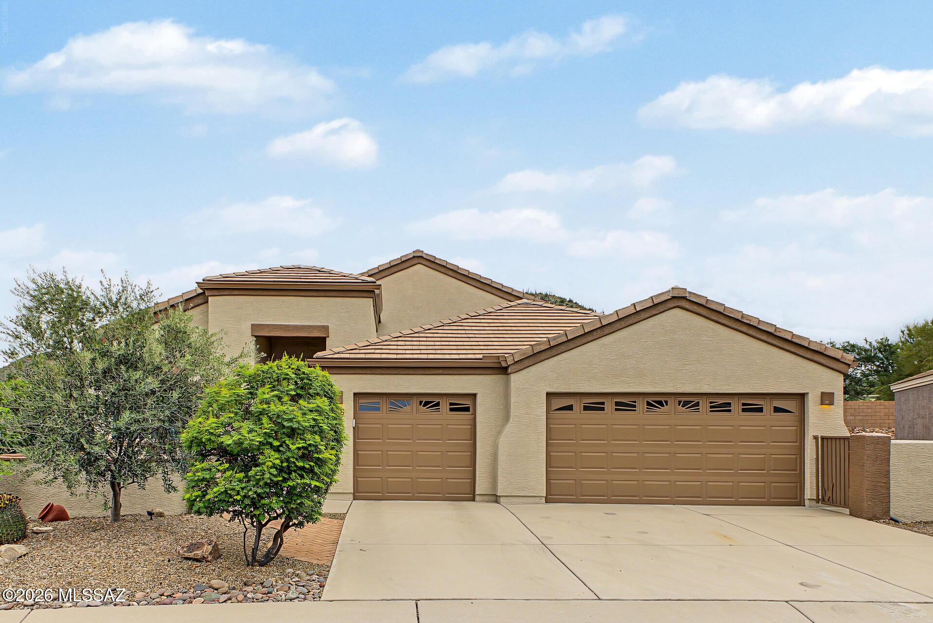 Welcome to The Highlands at Dove Mountain! This beautifully maintained 3-bedroom home is move-in ready with new windows, plantation shutters and fresh exterior paint. The renovated eat-in kitchen features quartz and granite countertops and opens to a cozy den with gas fireplace. A versatile front room provides additional living and now features a baby grand piano and dining area, although can be used as many different spaces. The primary suite offers a renovated bath with walk-in shower, while 2  additional bedrooms feature a Murphy bed with storage and built-in office furniture. Enjoy mountain views from the fully fenced, landscaped backyard with a large paver patio, built-in BBQ and multiple seating areas. A front courtyard and spacious 3-car garage with storage add to the appeal. Enjoy an active-adult lifestyle with golf, tennis, pickleball, pool, fitness center, bar and restaurant, clubs and social activities, all surrounded by Dove Mountain's beautiful desert scenery and nearby hiking and biking trails.