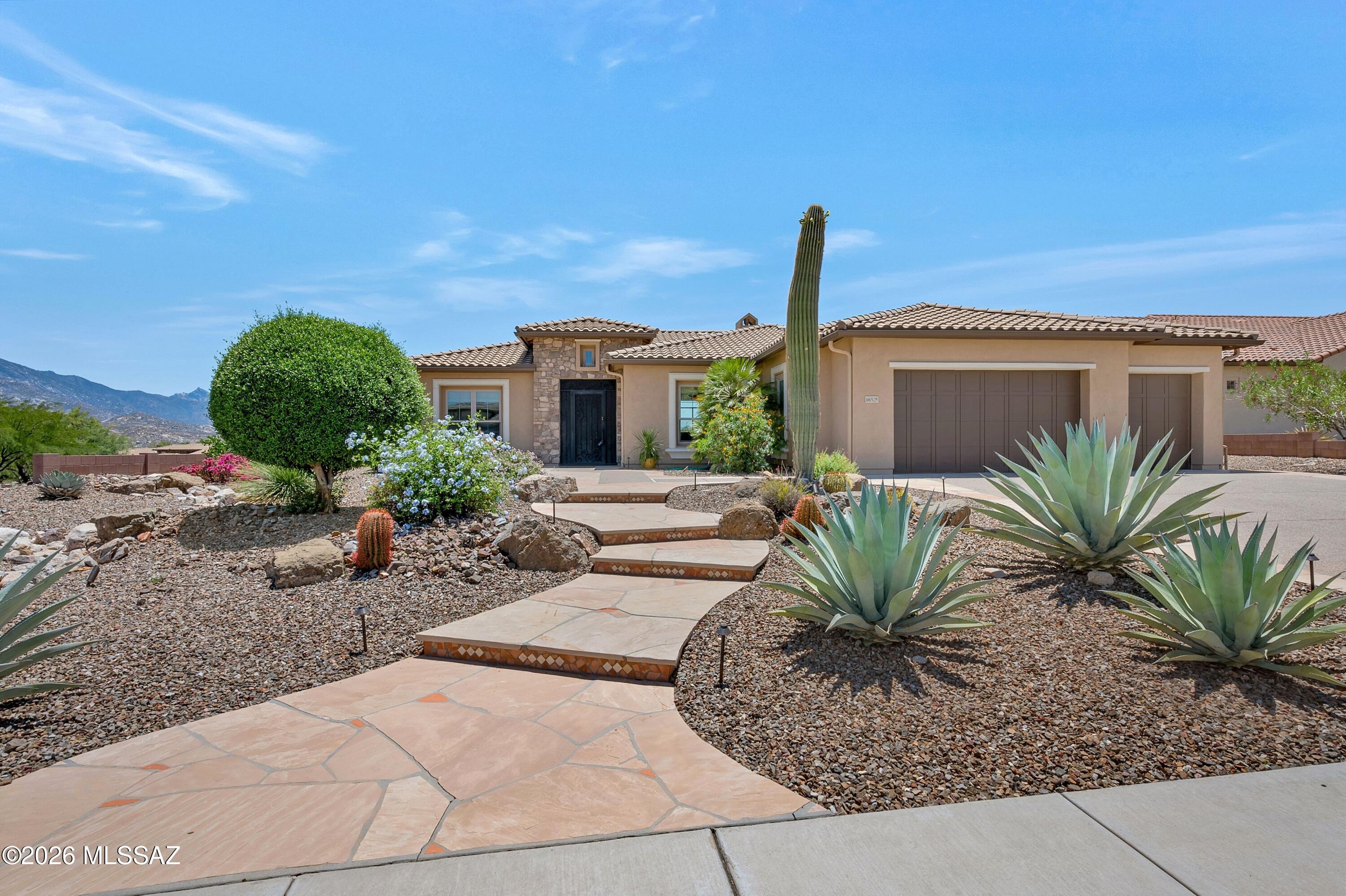 Panoramic vistas include the Catalina mountains and The Preserve Golf Course.
Set on an elevated corner lot above the 12th green. Elegant Sabino model showcases exceptional outdoor living space featuring a deep covered flagstone patio and additional patios of flagstone designed to capture the sweeping views.
This ideal desert home features a great room with 12-foot ceilings, a gas fireplace, and a wall of glass framing the beautiful views. The spacious kitchen includes a central island, granite countertops, and warm wood cabinetry, while the adjoining morning room provides a charming space for casual dining. Solid alder wood 8-foot interior doors are found throughout, and wood flooring extends through the great room, primary bedroom, and den, with tile in the entry, kitchen, and baths. The split-bedroom layout offers privacy, and both bedroom suites have exterior doors that open to the covered patio. Window treatments include plantation shutters, woven shades, and automated screens in the great room.
3 car garage with exterior door to the side yard.
South exposure from the back of the house and patio.