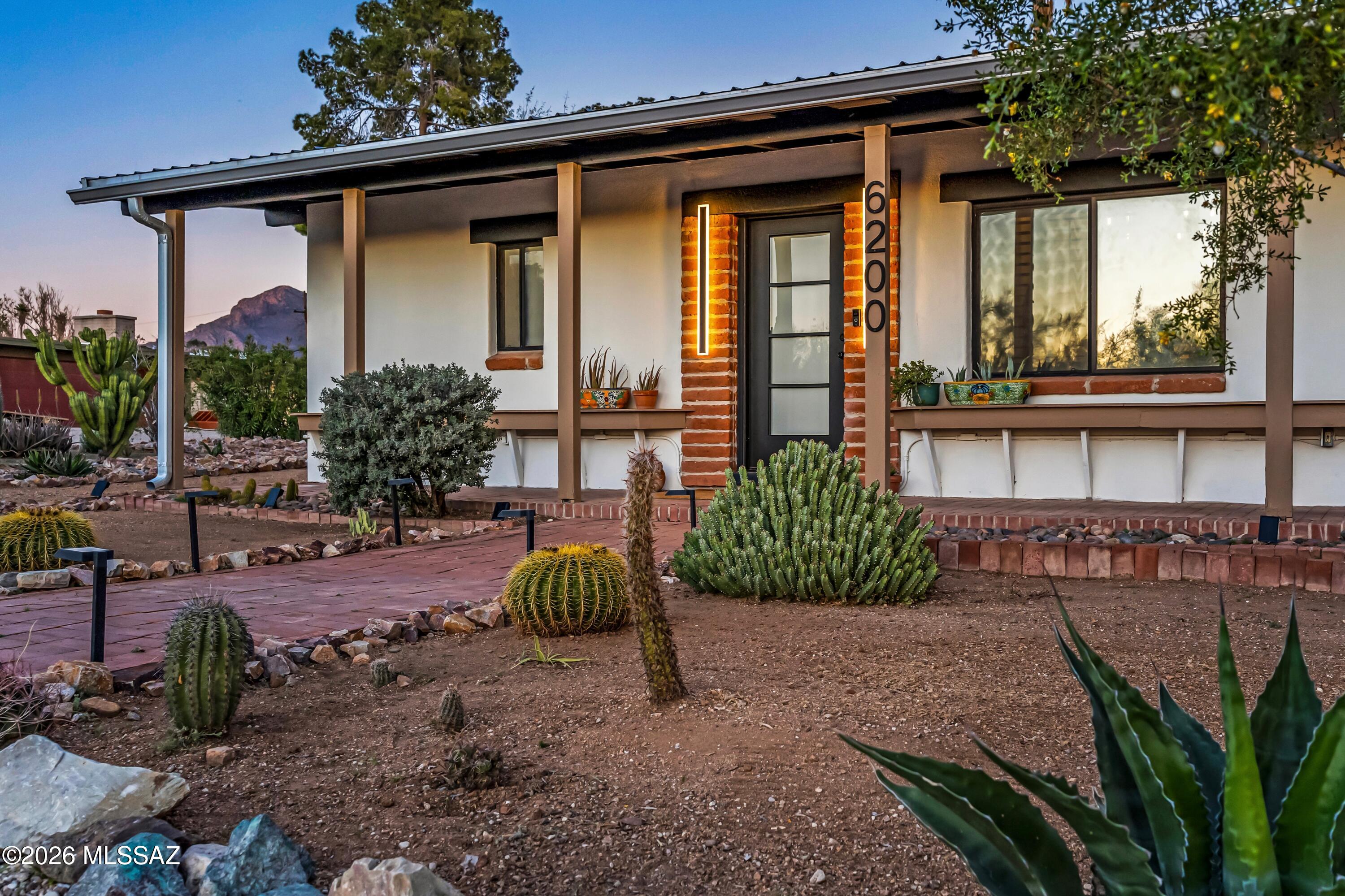A rare desert retreat where historic Tucson heritage meets refined modern living.

Set on 1.5 acres of untouched Sonoran Desert, this distinctive property is rumored to have once served as the original bunkhouse of a 26-acre ranch. Today, it has been thoughtfully reimagined into a private estate that blends rustic authenticity with clean, contemporary design.

The main residence offers three bedrooms, each with its own en suite bath, along with a thoughtfully placed powder room for guests. A versatile split floor plan offers both comfort and privacy. Warm, earthy textures pair beautifully with modern finishes, while the beautifully updated kitchen serves as the heart of the home--perfect for everyday living and effortless entertaining.

A series of intimate courtyards and inviting patios extend the living experience outdoors, offering spaces to gather, dine, or simply take in sweeping mountain and sunset views. Meandering solar-lit walking paths weave through native desert landscaping, creating a serene backyard experience beneath expansive Arizona skies.

Adding to the property's character is a charming adobe guest house (1 bed / 1 bath) featuring exposed beamed ceilings, custom wide doors, a convenient kitchenette, and a generous back patio--offering stylish and comfortable accommodations for guests or extended stays.

A two-car garage and ample off-street parking provide flexibility for both daily living and entertaining.

Private yet conveniently located near schools, shopping, and everyday amenities, this is a property that delivers unexpected beauty, authentic charm, and elevated desert living.