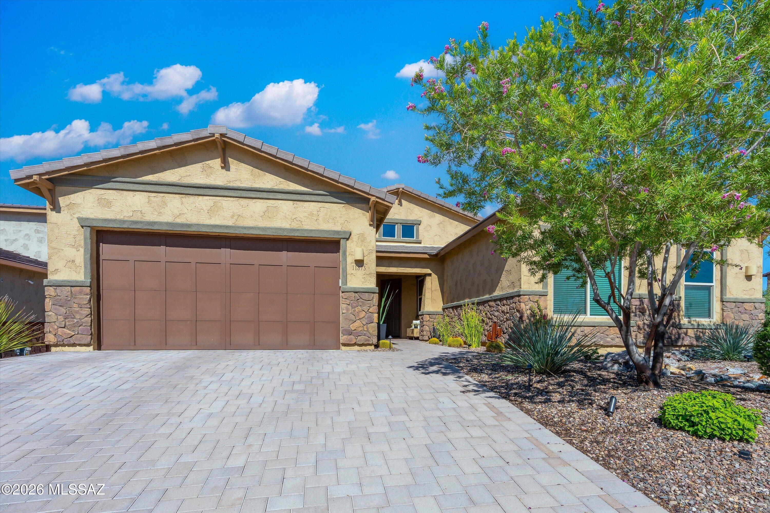 Sophisticated design, elevated finishes and effortless Arizona living come together in this exceptional single-story residence in Oro Valley's gated Villages at Silverhawke. Beautifully positioned on a corner lot, this 5-bedroom, 3-bath home with versatile flex space and an extended 3-car tandem garage offers an impressive combination of luxury, functionality and timeless style.
From the moment you enter, the home makes a statement. Soaring 10-foot ceilings, expansive living spaces, abundant natural light and a refined neutral palette create an atmosphere that feels both luxurious and inviting. The thoughtfully designed split-bedroom floor plan provides privacy while maintaining the open, connected spaces today's buyers love.
At the heart of the home is a stunning gourmet kitchen designe to be a true showpiece. A grand quartz island anchors the space with generous seating and an elegant gathering place for entertaining. Beautiful soft-close cabinetry, sophisticated tilework, under-cabinet lighting, stainless appliances and an oversized walk-in pantry with an extensive custom organization system blend elevated design with exceptional everyday functionality.
The kitchen flows seamlessly into the dining and great room, where an impressive 8-foot-wide extended sliding glass door fills the space with natural light and creates a beautiful connection to the outdoor living areas.
With five bedrooms plus a separate flex room, the floor plan offers incredible versatility--ideal for a private home office, media lounge, fitness room, reading retreat, playroom or teen space while maintaining generous accommodations for family and guests.
Privately positioned, the primary suite is a serene retreat featuring an additional sitting/dressing area and a spa-inspired bath with dual vanities, an oversized walk-in shower with beautiful tile detailing and a custom glass enclosure. A spacious walk-in closet with built-in organization completes the suite.
The extended 3-car tandem garage, with approximately four additional feet of space, provides valuable room for vehicles, storage and recreational gear.
Outside, the home's elevated design continues with a newly redesigned backyard created for effortless Arizona living. Expansive pavers, lush artificial turf and curated desert landscaping create a polished, low-maintenance setting with multiple spaces for outdoor dining, lounging and entertaining under the Arizona sky.
Located within gated Villages at Silverhawke, enjoy a spectacular Oro Valley setting with the Catalina Mountains as a stunning desert backdrop, plus community parks, playgrounds, a basketball court, sidewalks and miles of walking and biking paths connecting to The Loop. Naranja Park, Riverfront Park, Catalina State Park, El Conquistador Golf, Oro Valley Hospital, Oro Valley Marketplace, shopping and dining are all just minutes away.
Single-story living, sophisticated interiors, exceptional indoor-outdoor spaces and an incredible Oro Valley location--this is desert living, elevated.
