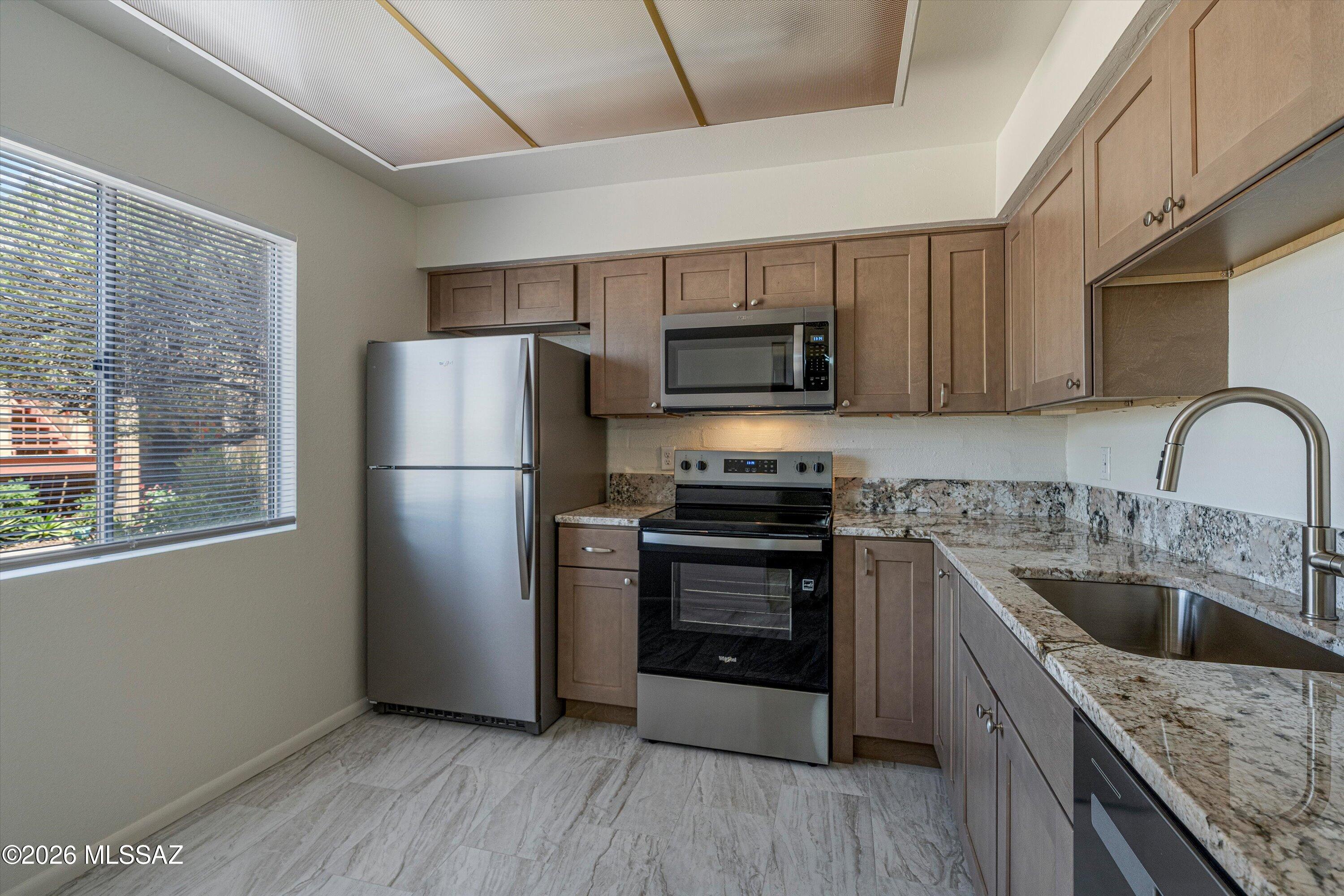 Move right into this stunning, fully remodeled 2-bedroom, 2.5-bath townhome featuring two spacious primary suites, each with its own private bathroom--perfect for roommates, guests, or a flexible living arrangement. The beautifully updated kitchen showcases custom cabinetry, elegant granite and quartz countertops, and brand-new stainless steel appliances, creating a stylish and functional space for cooking and entertaining. Throughout the home, you'll find new tile, luxury vinyl plank (LVP), and plush carpet flooring, offering a fresh, modern feel from top to bottom.  convenient half bath on the main level is ideal for guests. Located on the University of Arizona route, this home offers easy access to campus, downtown, shopping, dining, and public transportation. Covered parking spot too.