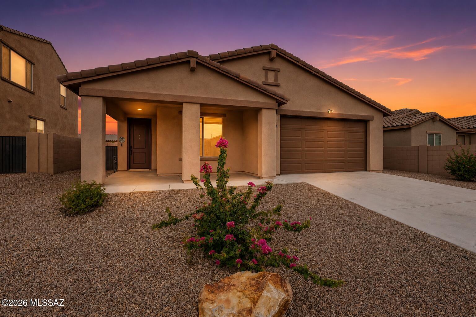 Every dream begins with the perfect home--and this one is ready to welcome your next chapter. Built in 2023 by Meritage Homes, this beautiful Colony floor plan blends modern design, energy efficiency, and everyday comfort in the highly sought-after master-planned community of Rancho Sahuarita. Here, you'll enjoy more than just a home--you'll become part of a vibrant community featuring resort-style pools, scenic lakes, neighborhood parks, walking trails, a fitness center, splash park, clubhouse, and a year-round calendar of events designed to bring neighbors together. Step inside and discover a home built with today's lifestyle in mind. Energy-efficient construction includes blown insulation in both the walls and attic, helping keep utility costs low while providing year-round comfort. Elegant tile flooring flows throughout the main living areas, while plush carpeting adds warmth and comfort to each bedroom. The heart of the home is an open-concept great room where family and friends naturally gather. A custom built-in electric fireplace creates a striking focal point, complemented by additional electrical outlets thoughtfully installed for today's entertainment needs. Whether hosting holidays or enjoying a quiet evening, this inviting space was designed to bring people together. The chef-inspired kitchen is as beautiful as it is functional, featuring sleek quartz countertops, stylish two-tone cabinetry, a decorative tile backsplash, a gas range, spacious pantry, and an oversized island that invites casual dining and conversation. The well-equipped laundry room includes the washer and dryer, upper storage cabinets, and a convenient utility sink, making everyday chores a little easier. The spacious primary suite offers a peaceful retreat at the end of the day, complete with a spa-inspired bathroom featuring dual vanities, a large walk-in shower, and an oversized walk-in closet. The thoughtfully designed Jack-and-Jill bathroom also offers dual vanities and a shower/tub combination, making it ideal for family members or overnight guests. Need extra space? The three-car tandem garage provides endless possibilities with room for a workshop, home gym, hobby space, golf cart, or abundant storage. Outside, the backyard is a blank canvas ready for your personal vision. Create the desert oasis you've always imagined with plenty of room for entertaining, relaxing, or adding a pool--all while enjoying peekaboo views of the surrounding mountains. Why wait months for new construction when you can move into a nearly new home with premium upgrades already completed? Combining modern finishes, exceptional energy efficiency, flexible living spaces, and one of Southern Arizona's most amenity-rich communities, this home offers the perfect balance of style, comfort, and lifestyle. Welcome home to Rancho Sahuarita, where every day feels like a vacation.
