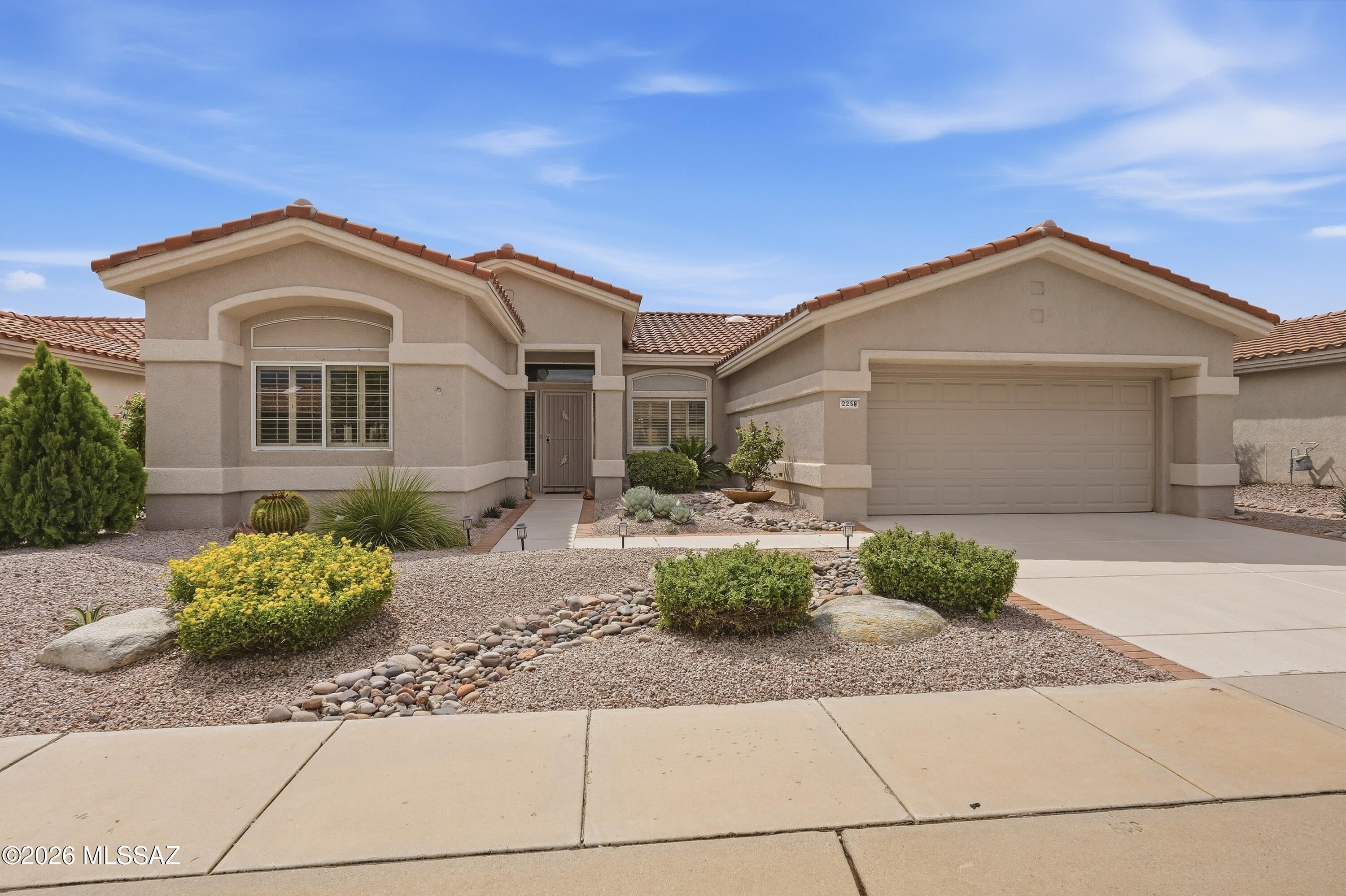 This Hampton model offers three bedrooms and three bathrooms. The high ceilings and plantation shutters create an airy, bright open feel throughout the living spaces. The spacious primary bedroom has sliders to the rear to take in the view and features a walk-in closet, and the en-suite bathroom includes a garden soaking tub.  The kitchen has stainless steel appliances with granite tiles and backsplash and breakfast nook. The formal dining and living area is a separate, designated space, and the ceramic tile flooring is arranged in a diagonal pattern, adding visual interest. The split bedroom layout allows for privacy and flexibility in how the space is utilized. Ceiling fans in multiple rooms. Laundry room has a sink with washer and dryer. Oversized garage with tandem golf cart space.
