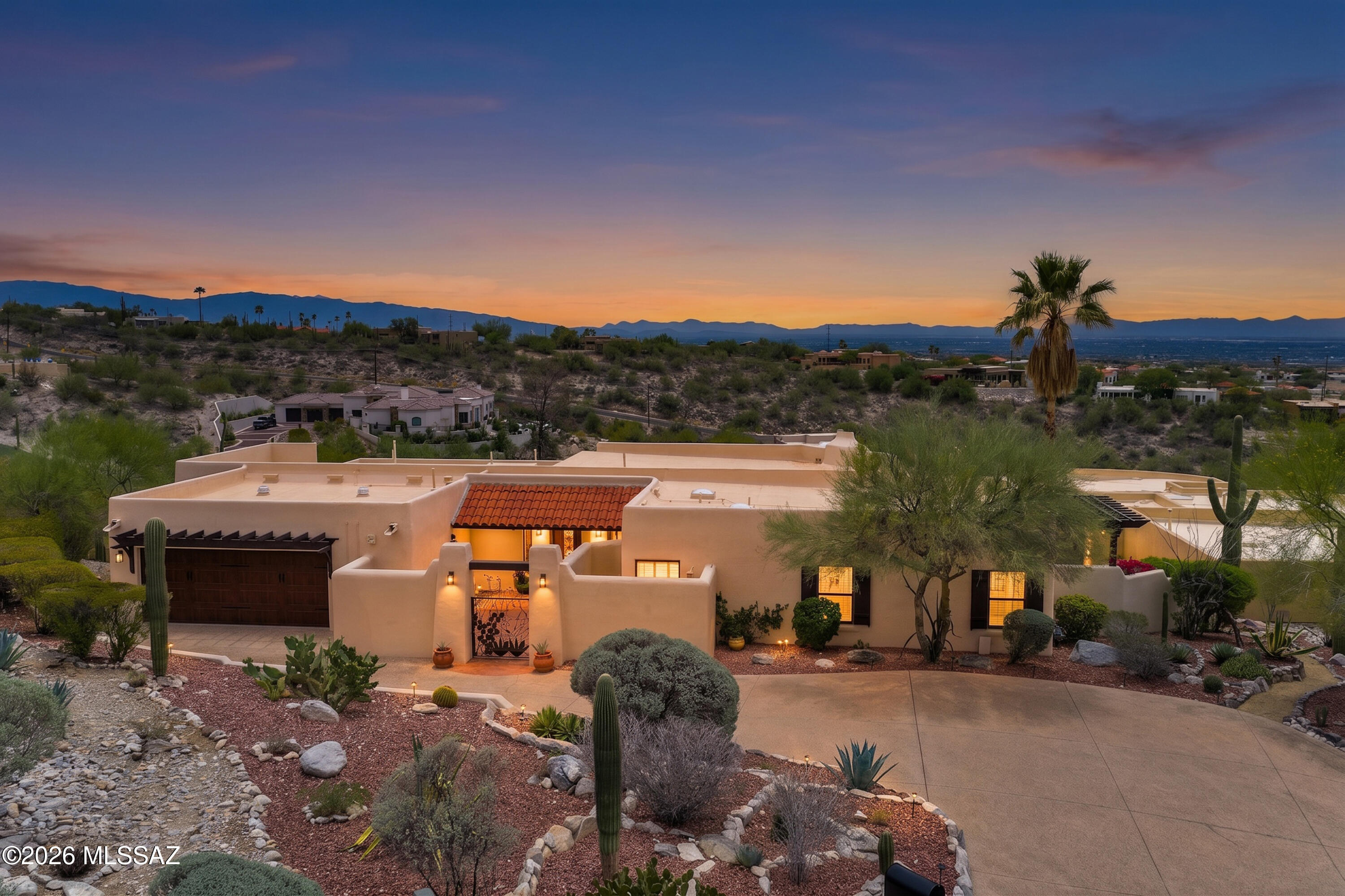 Completely renovated luxury home in the prestigious 24-hour manned guard-gated community of Sin Vacas. Situated on 1.12 acres, this 3,352 SF residence offers 3 bedrooms, 2.5 baths, a 2-car garage, pool, spa, and a CLEAR PANORAMIC VIEW OF CITY LIGHTS AND MOUNTAIN VIEWS. Showing in the evening is encouraged to capture the CITY LIGHTS. The open-concept great room features warm wood beams, French doors, abundant natural light, and custom reclaimed Oregon barn wood accents. The 2019 chef's kitchen showcases GE stainless appliances, an oversized quartz island, quartz countertops, farmhouse sink, wine refrigerator, and custom cabinetry with crown molding.  Enjoy a wraparound porch, multiple outdoor living spaces, and the award-winning CATALINA FOOTHILLS DISTRICT 16 SCHOOLS